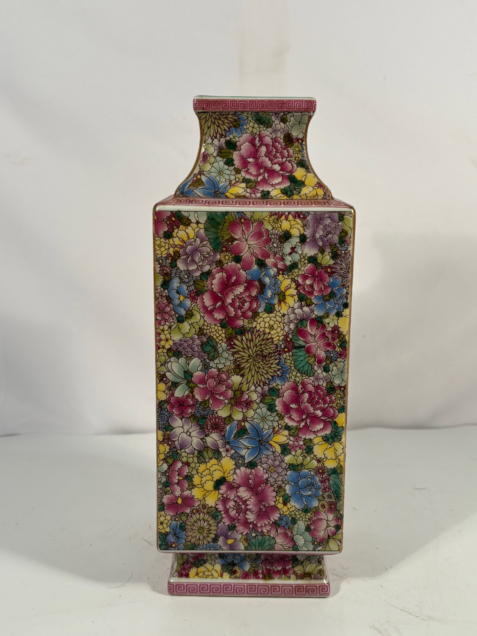 A Chinese Famille-Rose Millefleurs Square Vase with YONGZHENG Mark: Early 20th century; A square famille-rose porcelain vase, each side densely decorated in bright enamels with an allover millefleurs (wanhua) floral design, including peonies, chrysanthemums, lotus, an