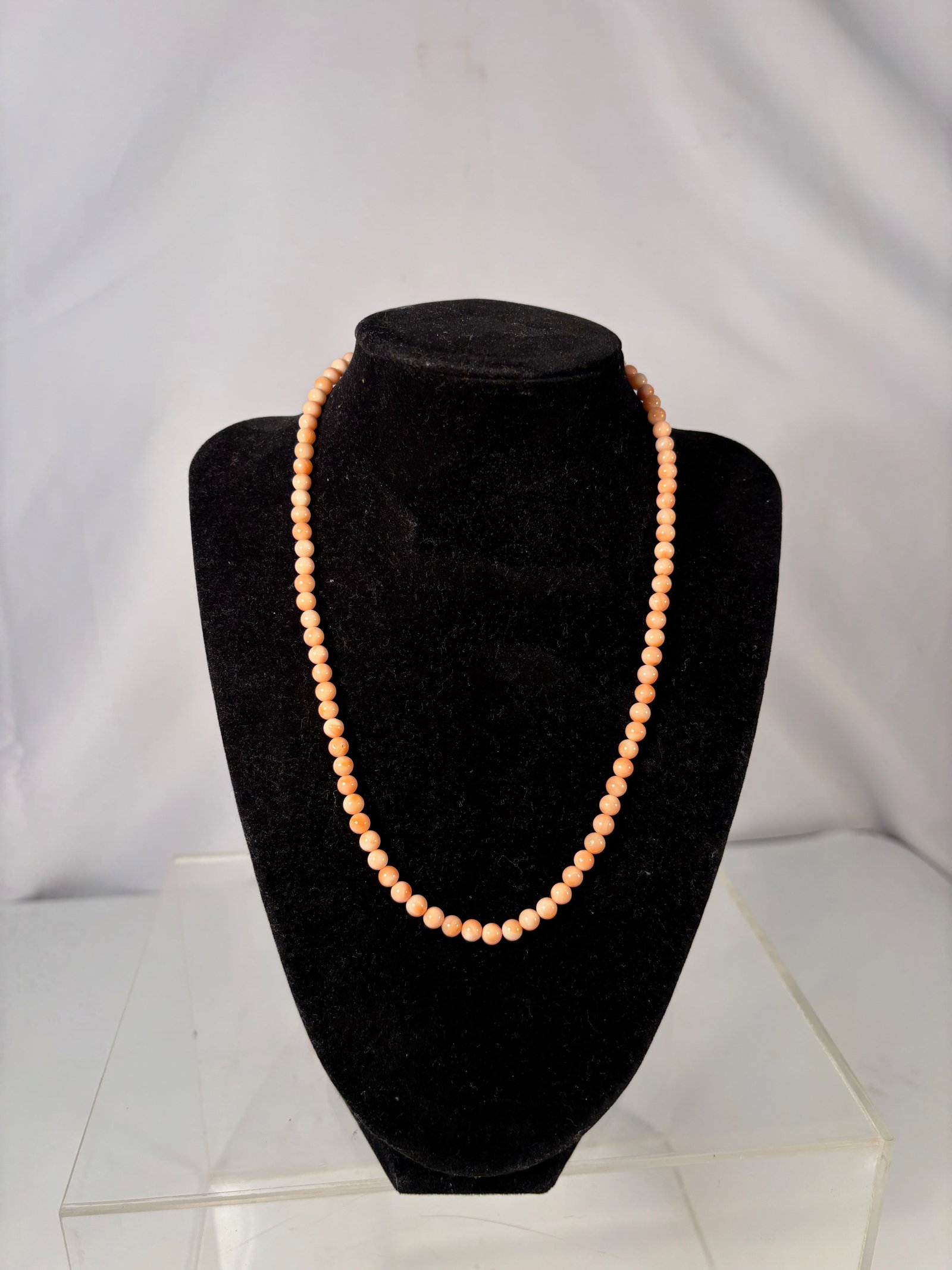 A Vintage Salmon Coral Bead Necklace: A vintage strand of natural salmon coral beads, exhibiting a warm peach-pink tone with subtle organic variation characteristic of coral. The beads are evenly shaped and well matched, strung as a singl