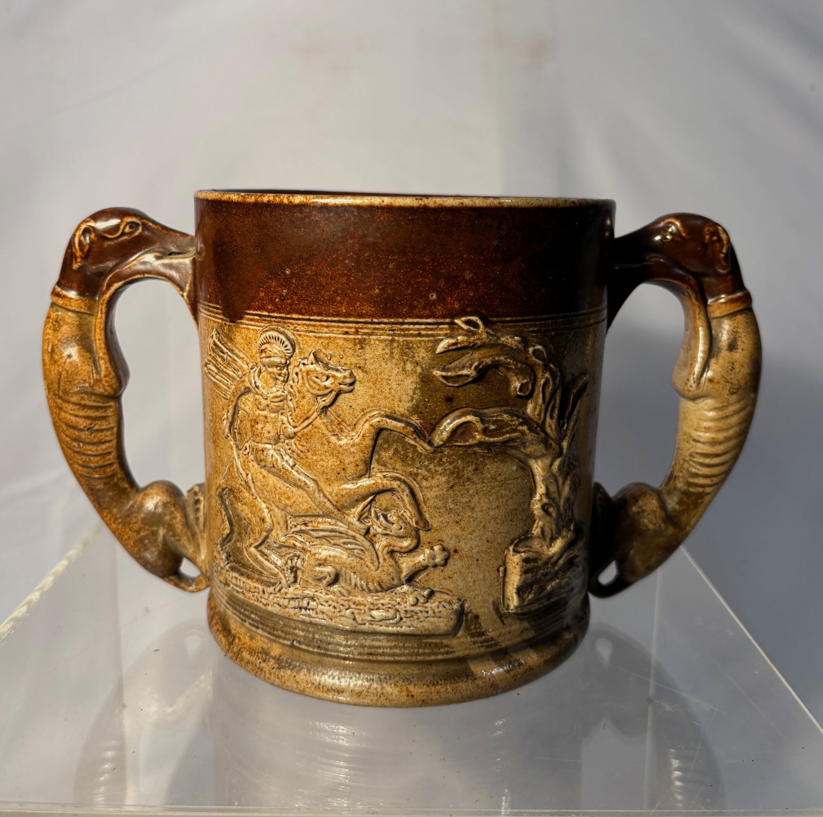 Antique Royal Doulton Lambeth Hunting Scene Stoneware Loving Cup: This vintage Royal Doulton Lambeth loving cup features ornate hunting scene reliefs and dual dachshund-form handles. It’s a fine collectible with historical charm. Two-tone brown glaze. Late 19th ce