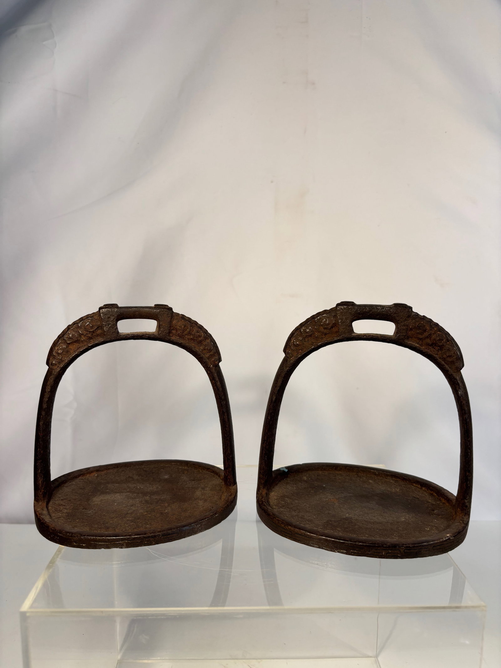 Pair of Chinese Iron and Silver-Inlaid Stirrups, Qing Dynasty: Qing dynasty(1644-1912); A finely crafted pair of iron stirrups, each of oval form with arched handle and flat treadplate, the surfaces delicately inlaid in silver wire with interlocking key-fret and 
