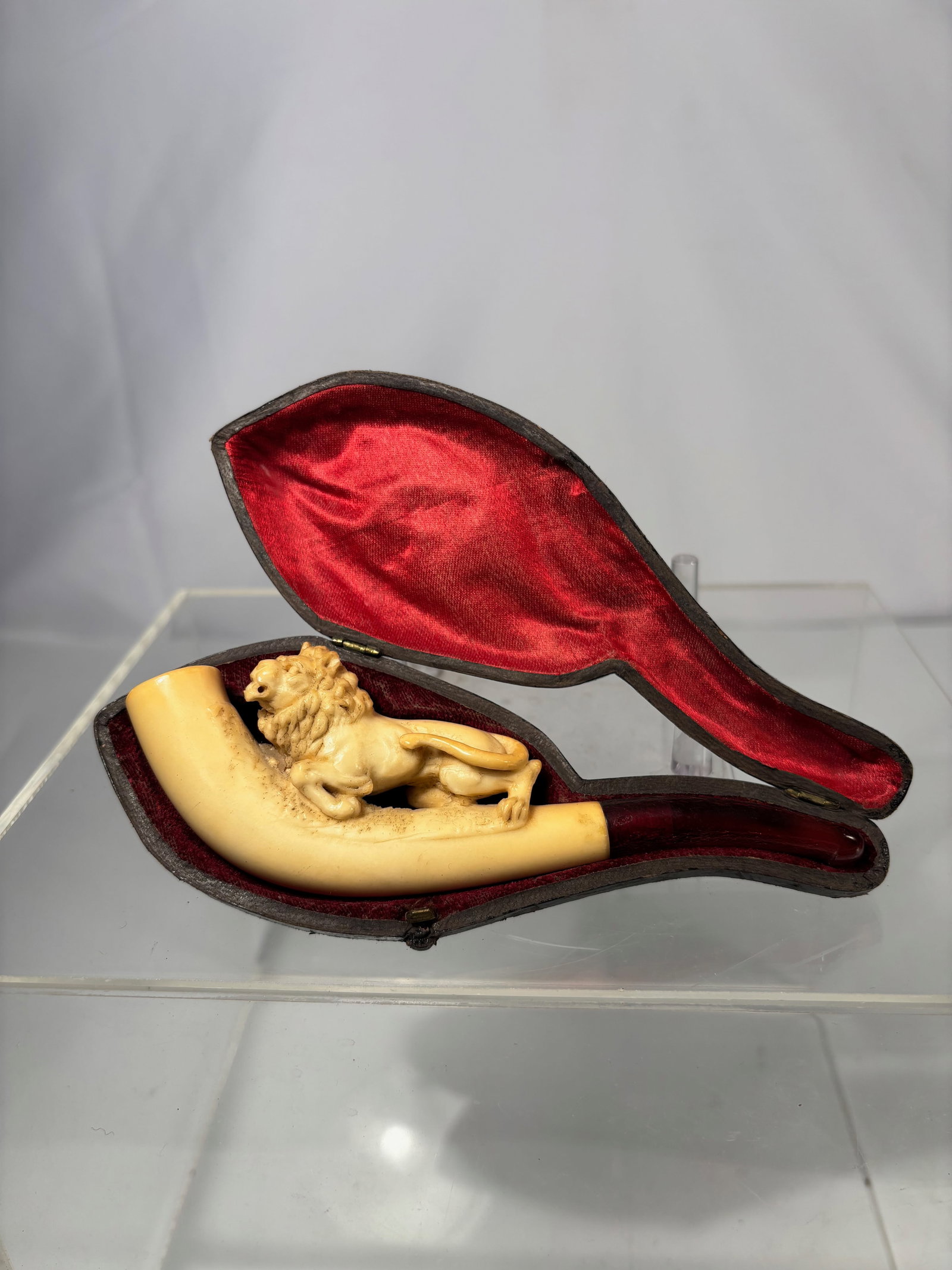 A Carved Meerschaum Figural Smoking Pipe with Fitted Case, c.1900: Antique carved meerschaum figural smoking pipe, finely sculpted and fitted with a curved amber mouthpiece (stem). The meerschaum shows natural patination consistent with age and use. Retains its origi