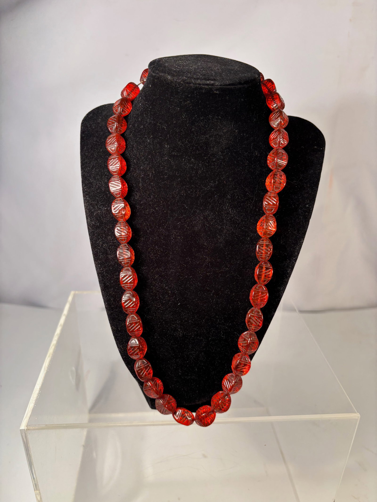 A Vintage Bohemian Carved Orange Glass Bead Necklace: Vintage necklace composed of carved orange pressed glass beads with decorative molded patterns. The beads display attractive internal glass striations typical of early Bohemian glass production. Lengt