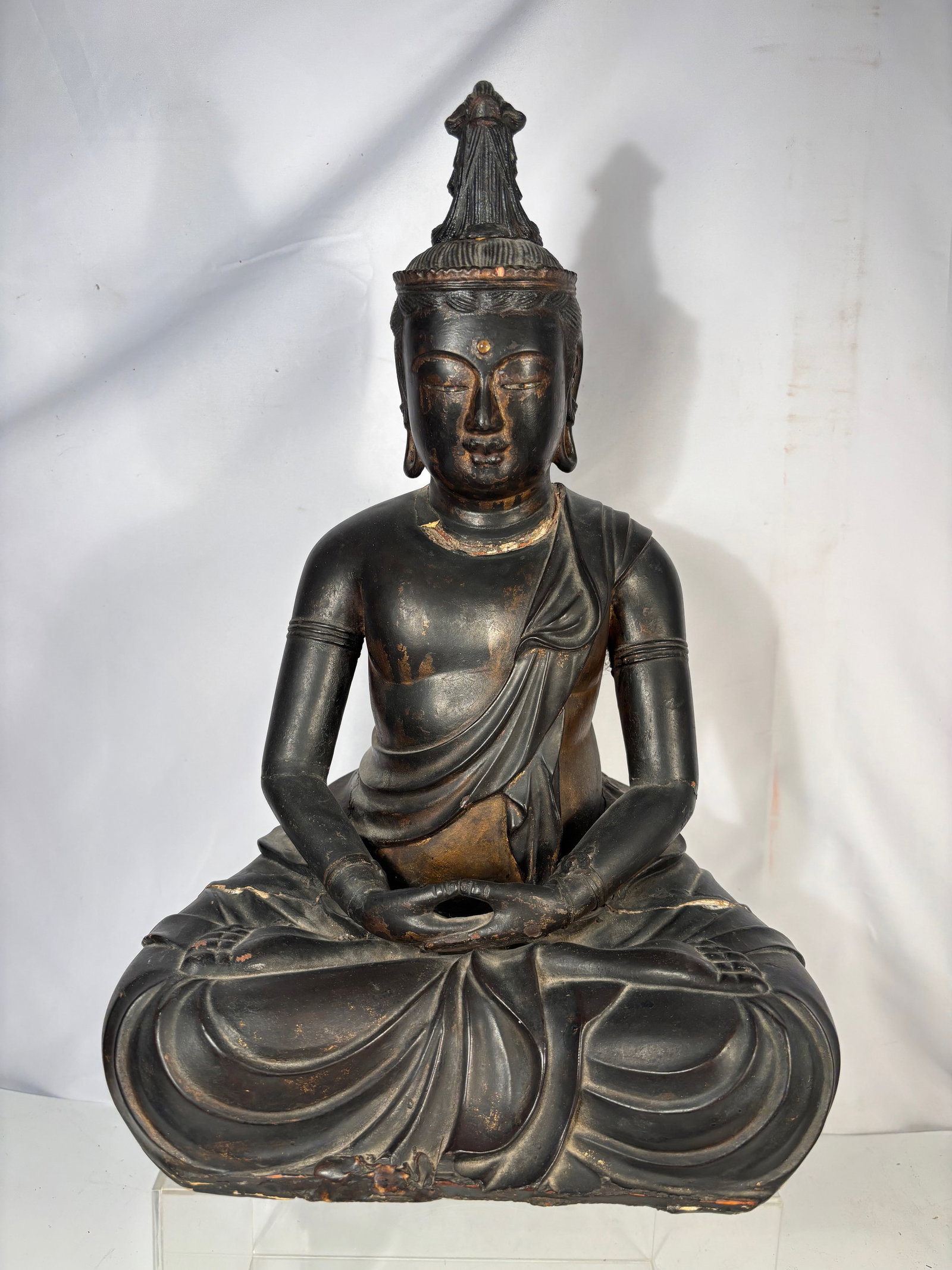 A Japanese Carved Wooden Seated Amida Buddha, Edo Period (18th century) or early: A Japanese carved wooden seated Buddha figure, likely Amida Nyorai, Edo period (18th–19th century). Depicted seated in meditation with hands in dhyana mudra and wearing a draped robe. Constructed in