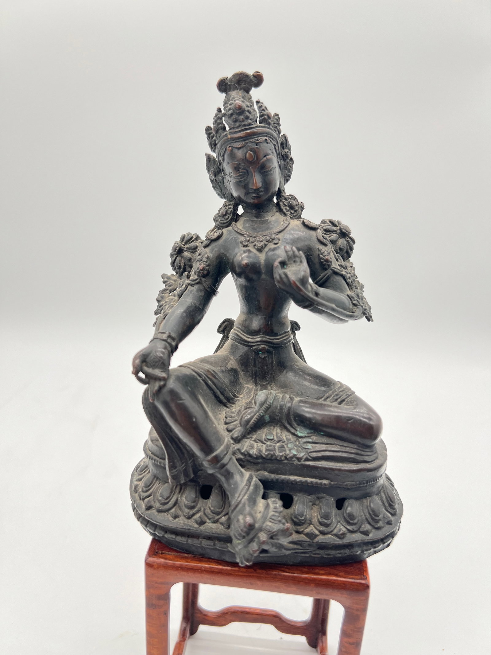 A Nepalese bronze Buddha statue: The figure’s adornments, serene expression, and seated posture reflect typical representations of deities like Tara, Avalokiteshvara, or other Bodhisattvas in Nepalese Buddhism. Dimensions?Height: 7