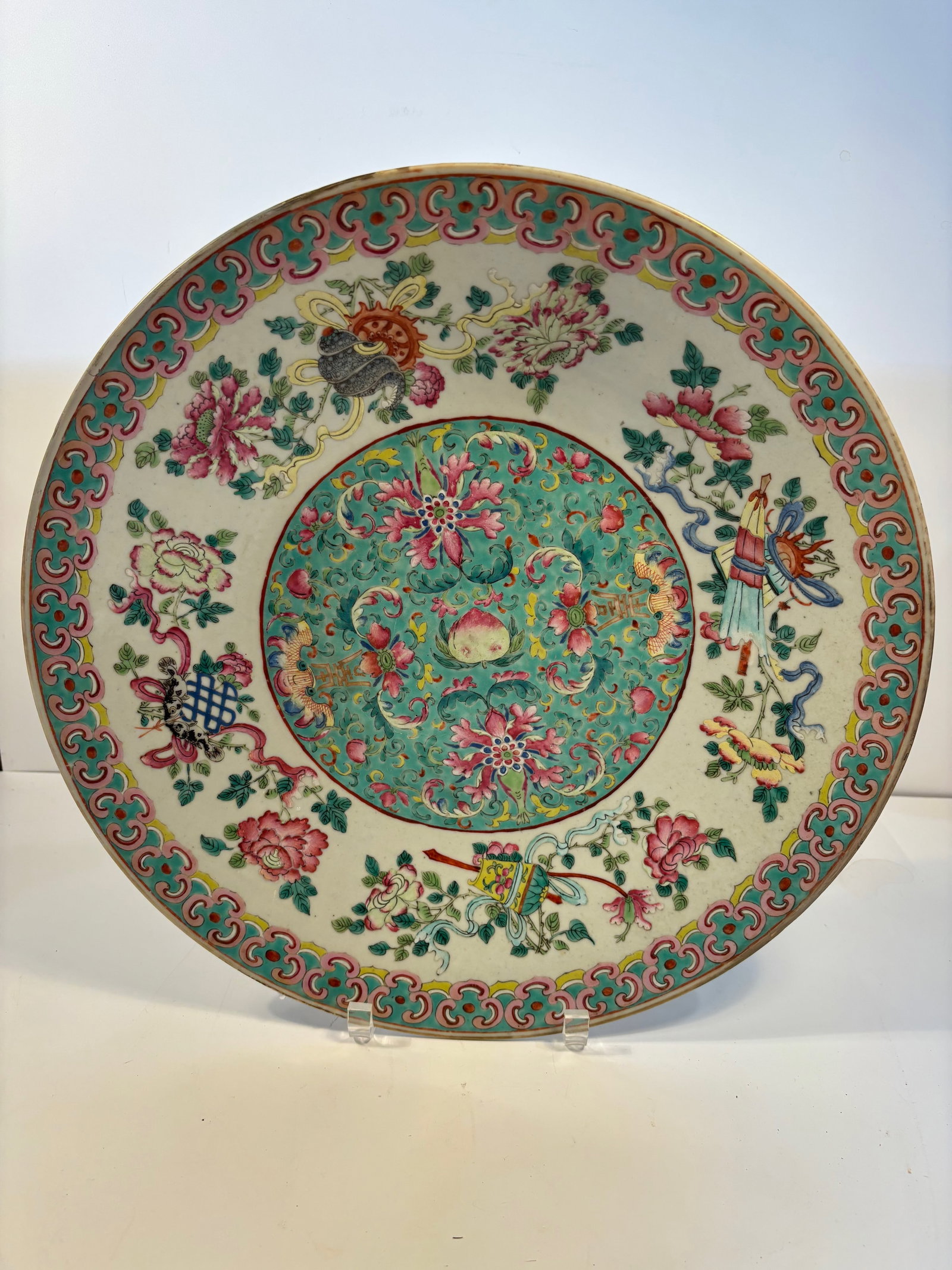 A Super large Chinese famille rose porcelain charger: Late 19th to early 20th, the central features a beautiful scrolling lotus or peony design with a central longevity peach, The band around the rim uses a common “ruyi head” pattern. Dimensions?