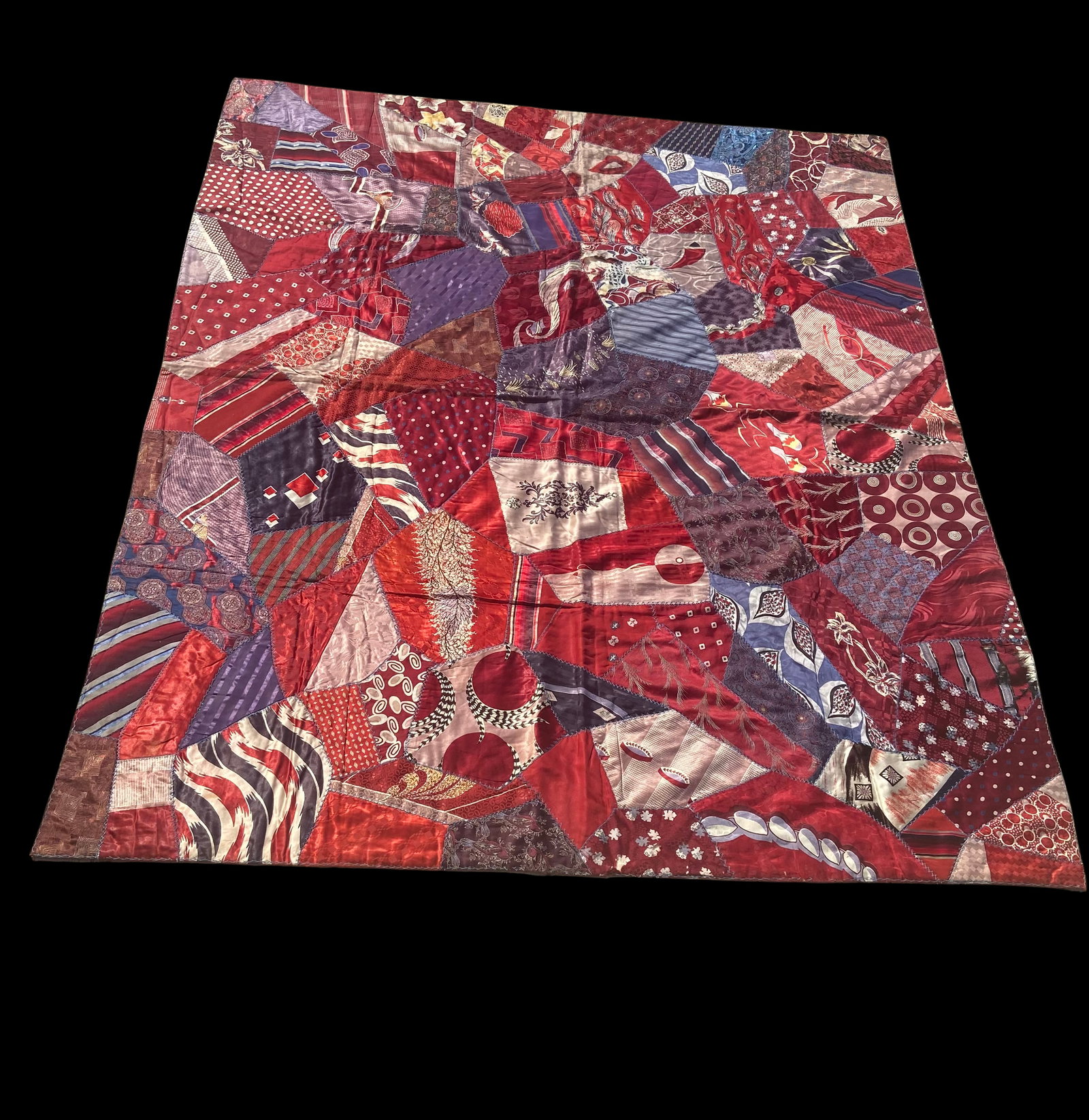 Vintage Handmade Crazy Quilt, Red & Purple Silk Patchwork Folk Art Textile: This vintage handmade crazy quilt features an expressive patchwork design composed of irregularly shaped silk and satin fabric pieces in rich tones of red, burgundy, and purple. The composition showca
