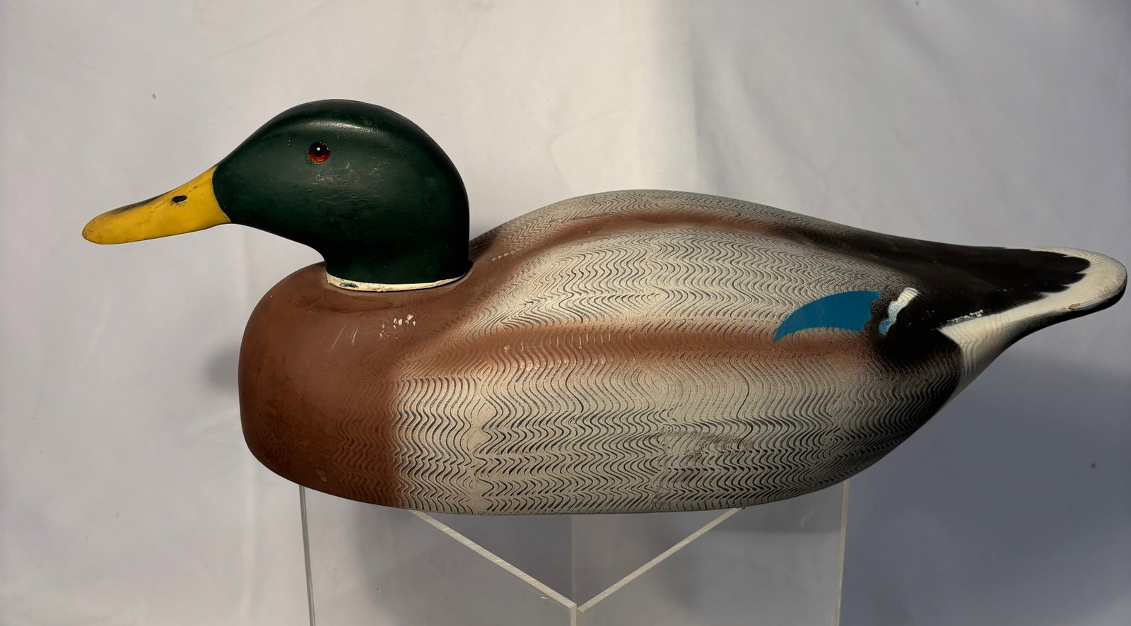 A Mid Century Hand Painted Duck Hunting Decoy by Decoys Unlimited: Vintage hand-painted carved duck decoy bearing “Decoys Unlimited” label for Erie, Pennsylvania. Decorative sporting art example with painted surface and carved form. Length: 18 inches , Width: