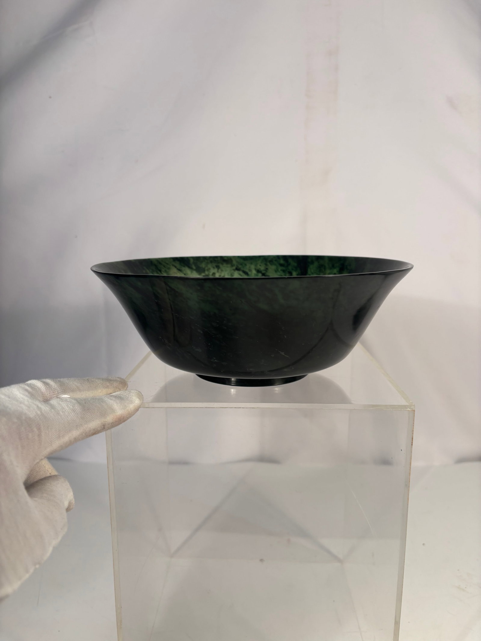 A Chinese Carved Green Spinach Jade Bowl: It is a Chinese vintage jade bowl, frequently referred to as a "spinach green" jade bowl due to its dark green color with darker inclusions. Diameter: 5 inches; Height:2 inches.
