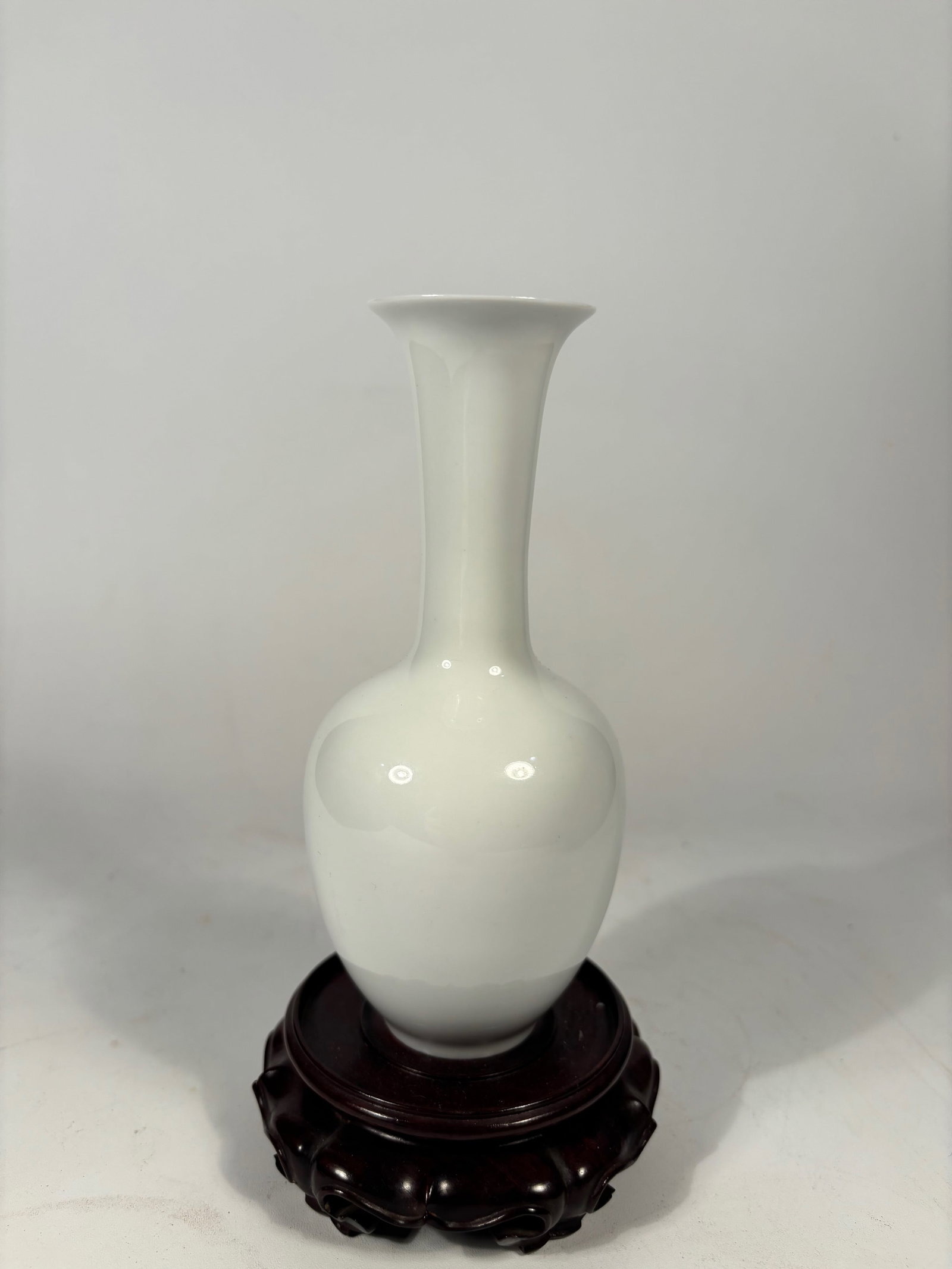 A Chinese White Glazed Porcelain Vase by BO JIA: LATE 19TH TO EARLY 20TH CENTURY; A white-glazed porcelain vase with a bulbous body rising to a tall flaring neck, covered in an even translucent glaze. The base bears a six-character underglaze blue