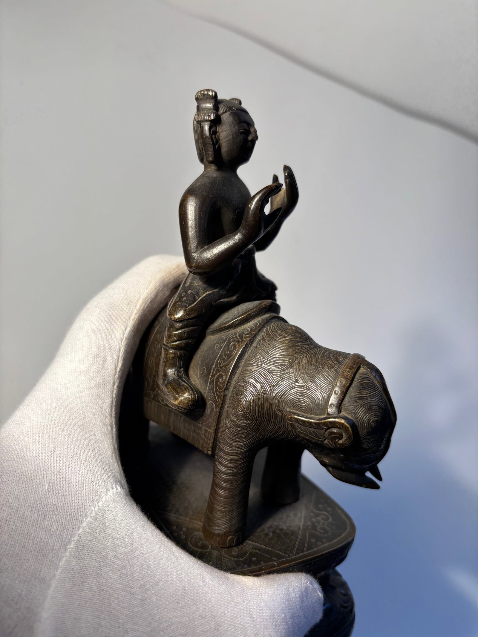 A Tibetan Bronze figure statue: Late 19th century , It features multiple arms and faces Seated on a lotus pedestal, with engraved decorations. Dimensions?Height: 7.25 inches.