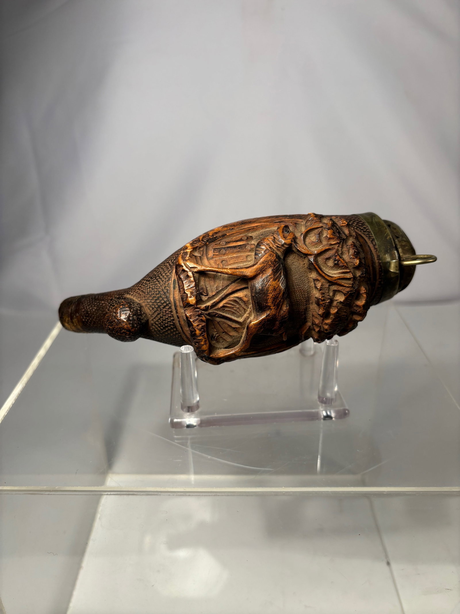 A Carved Wooden Figural Tobacco Pipe, Ulmer Kloben–Style, Brass Hinged Lid: A carved wooden figural tobacco pipe, the body deeply carved in high relief with a grotesque mask-like face and layered foliate and textural details. The pipe is fitted with a hinged brass bowl cover,
