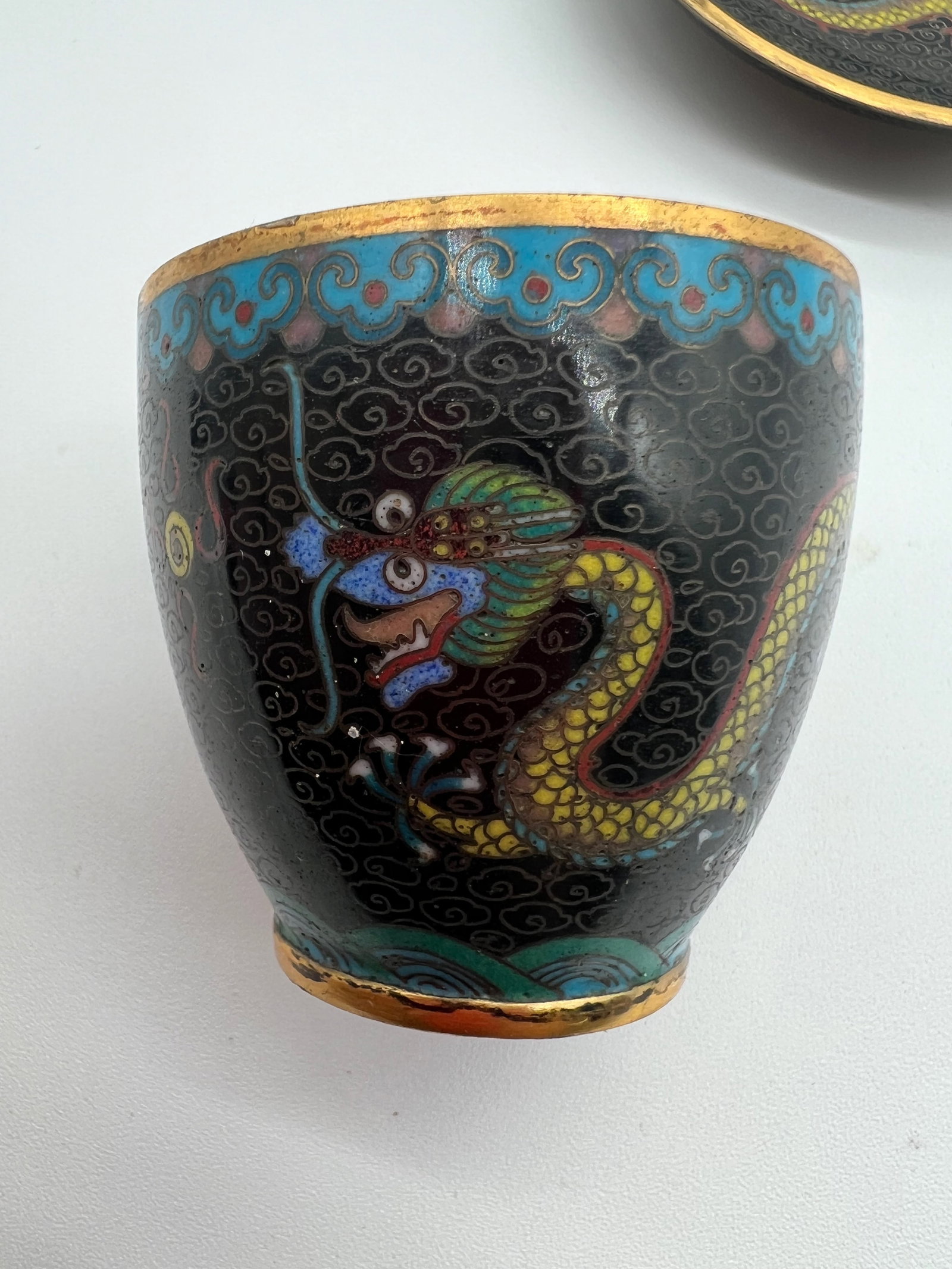 A Chinese cloisonné dragon gilt cup: Qing dynasty (1644-1912);This cup is very heavy gilt. . The dragon is a central design element, coiled around the body of the cup. The upper rim has a decorative band, possibly featuring floral or clo