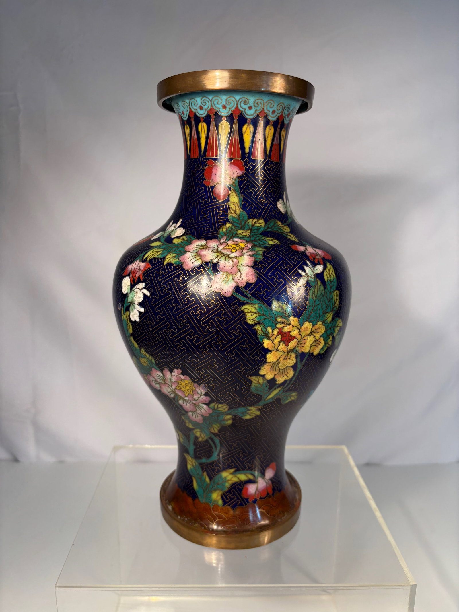 A Chinese Cloisonné Enamel Vase: Baluster-form vase with waisted neck, decorated in brightly colored cloisonné enamels against a deep cobalt-blue ground patterned with a repeating leiwen (thunder-scroll) motif. The body finely worke