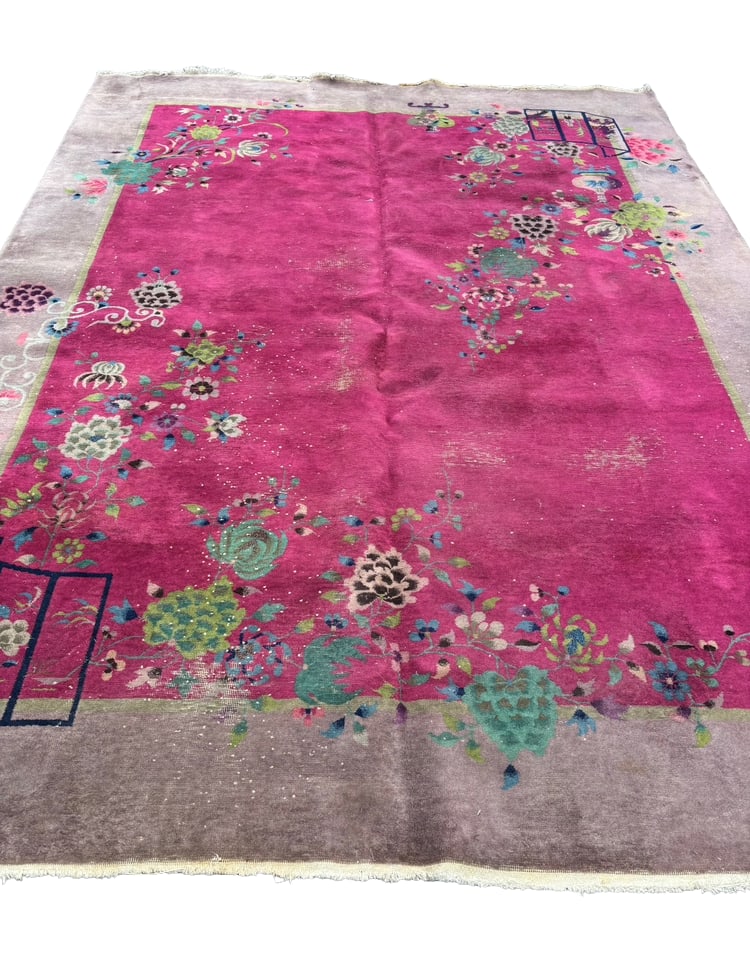 1930s Chinese Art Deco Rug with Floral Motif: Hand-knotted Chinese Art Deco carpet, likely dating to the 1930s, featuring a vivid fuchsia field with floral sprays and geometric screen-form motifs on a muted lavender border. The rug displays a dis