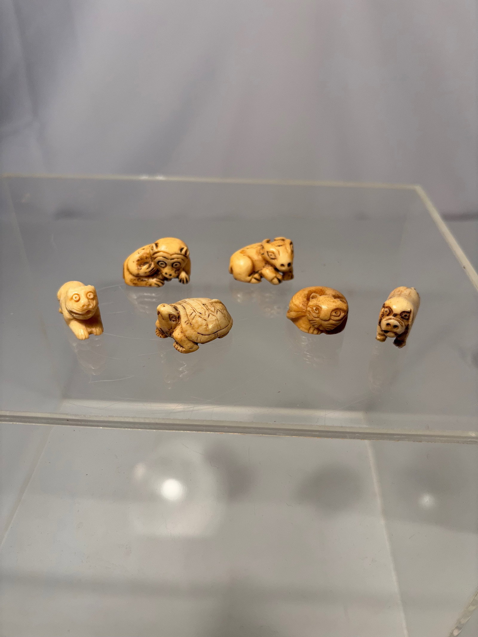 Group of Six Japanese Miniature Carved Bone Animals: 19th -20th century, Group of six miniature carved bone figures depicting animals, each carved in the round with incised details and expressive forms. The carvings show natural tonal variation and