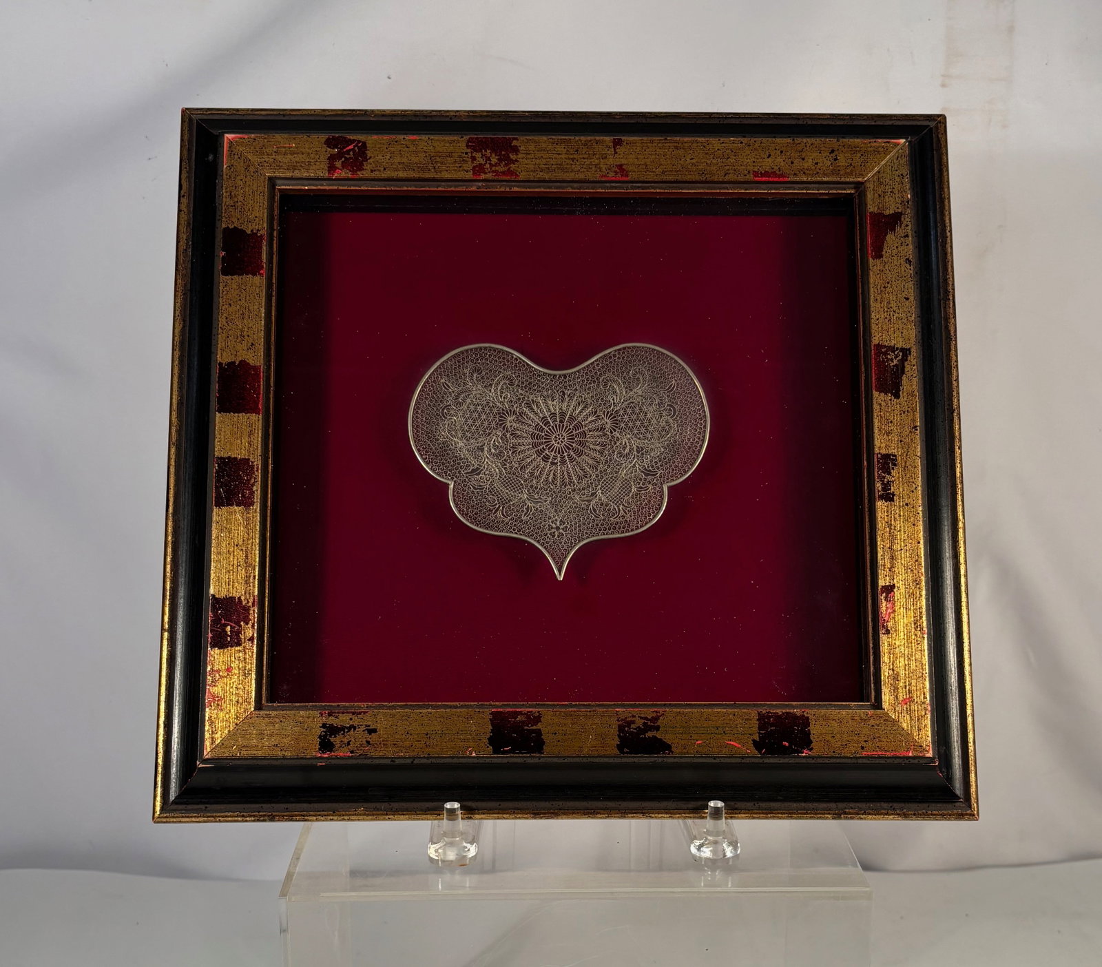 A European Silver Filigree Ornament , Framed: Antique European silver filigree ornament of stylized cloud or heart form, intricately worked with delicate wire filigree featuring a central floral rosette and scrolling motifs. Likely late 19th to e