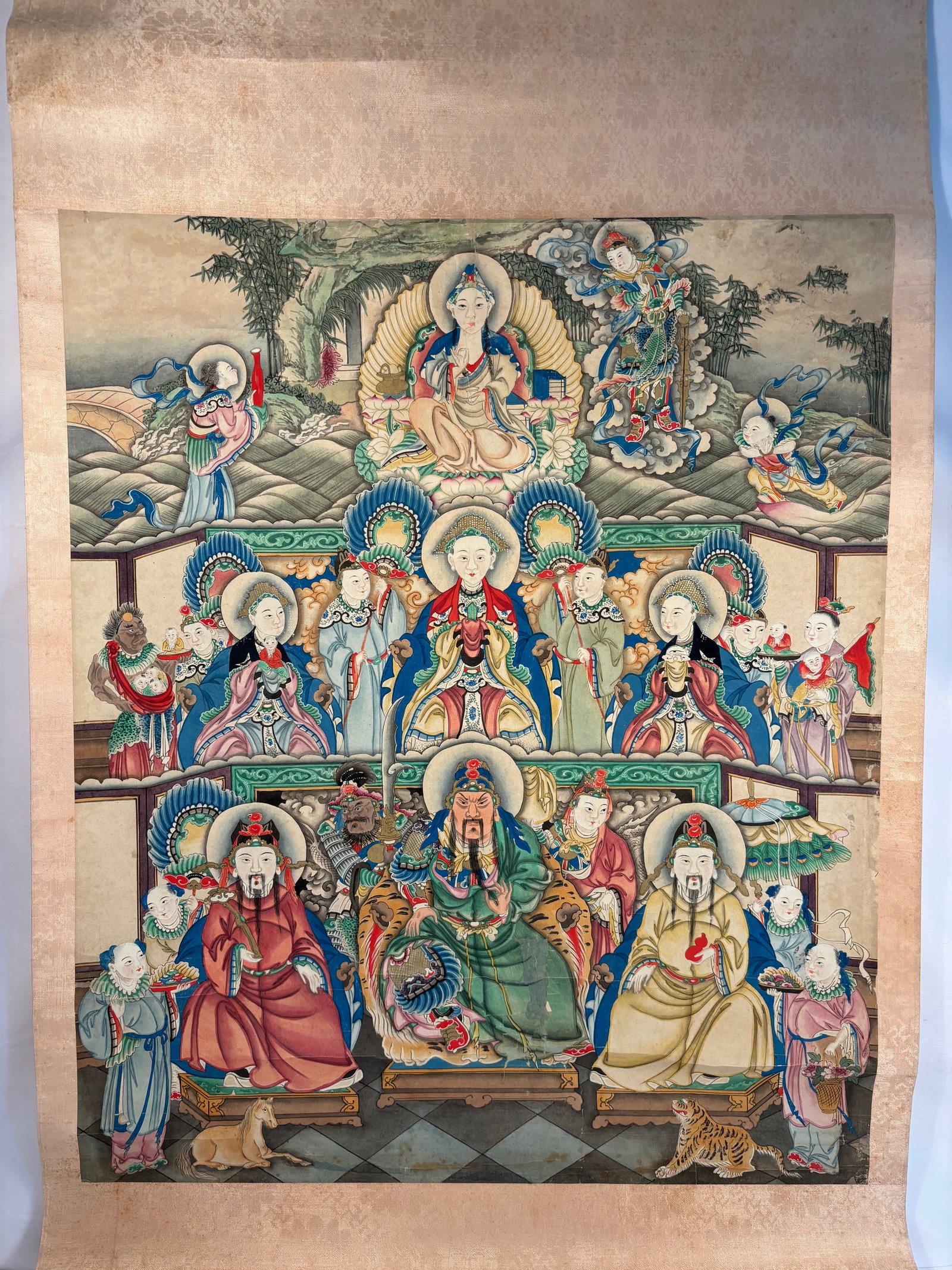 A Chinese Polychrome Scroll Painting of Daoist Immortals and Shoulao: Qing dynasty(1644-1912); Vividly painted in bright mineral pigments on silk, depicting Shoulao, the God of Longevity, enthroned at center surrounded by an assembly of Daoist immortals and attendants, 