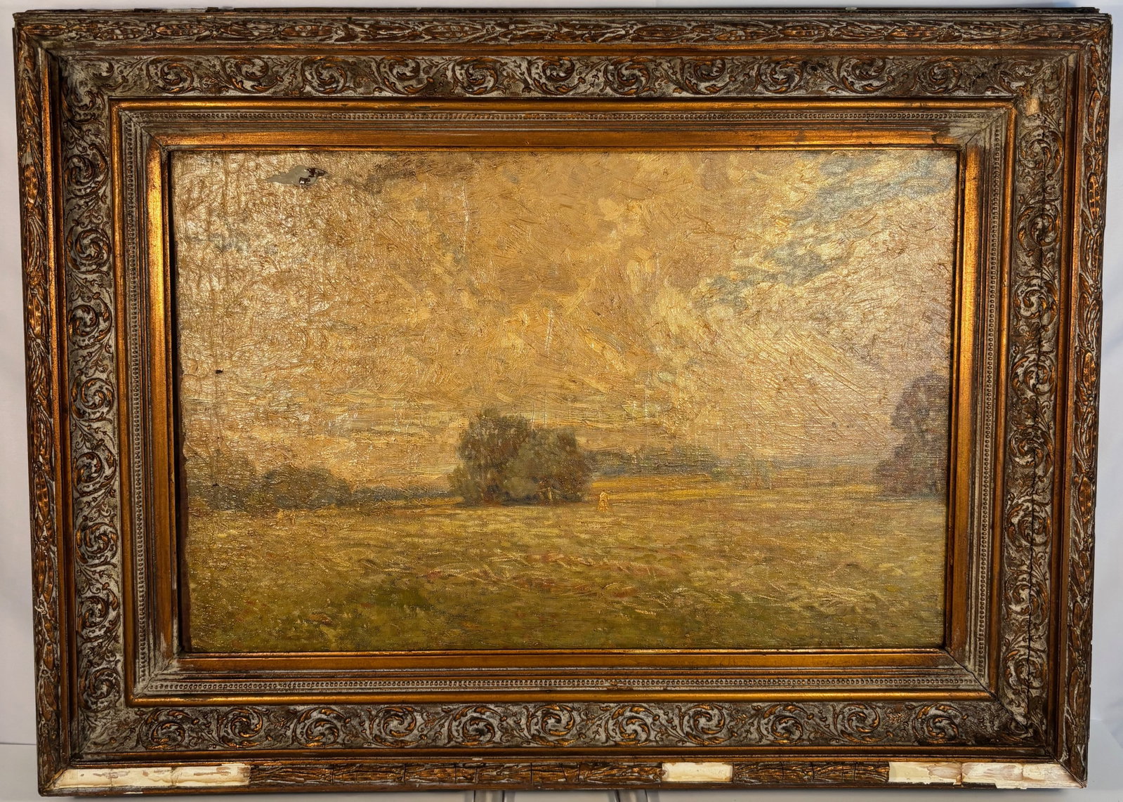 Oil on Panel Landscape Painting, Pastoral Field with Trees: 19th century to early 20th century; depicting an open pastoral field with trees under a clouded sky. A small figure or haystack appears in the distance, adding depth to the serene countryside view. Th
