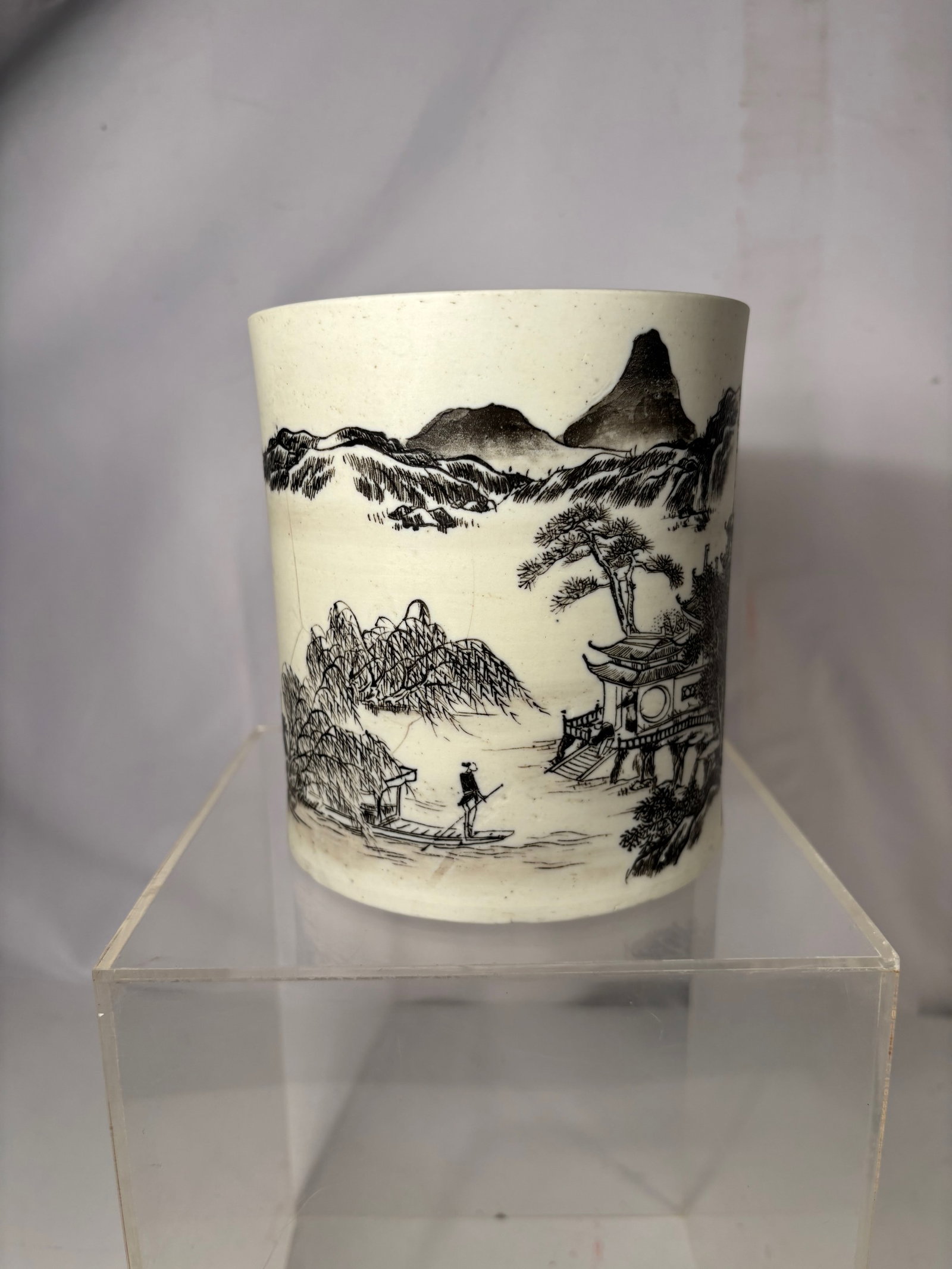 A Chinese Biscuit Porcelain Landscape Bitong (Brush Pot): 18th Century, A Chinese porcelain bitong (brush pot) of cylindrical form, decorated with a continuous landscape scene depicting mountains, pavilions, trees, and figures in a traditional ink-style comp
