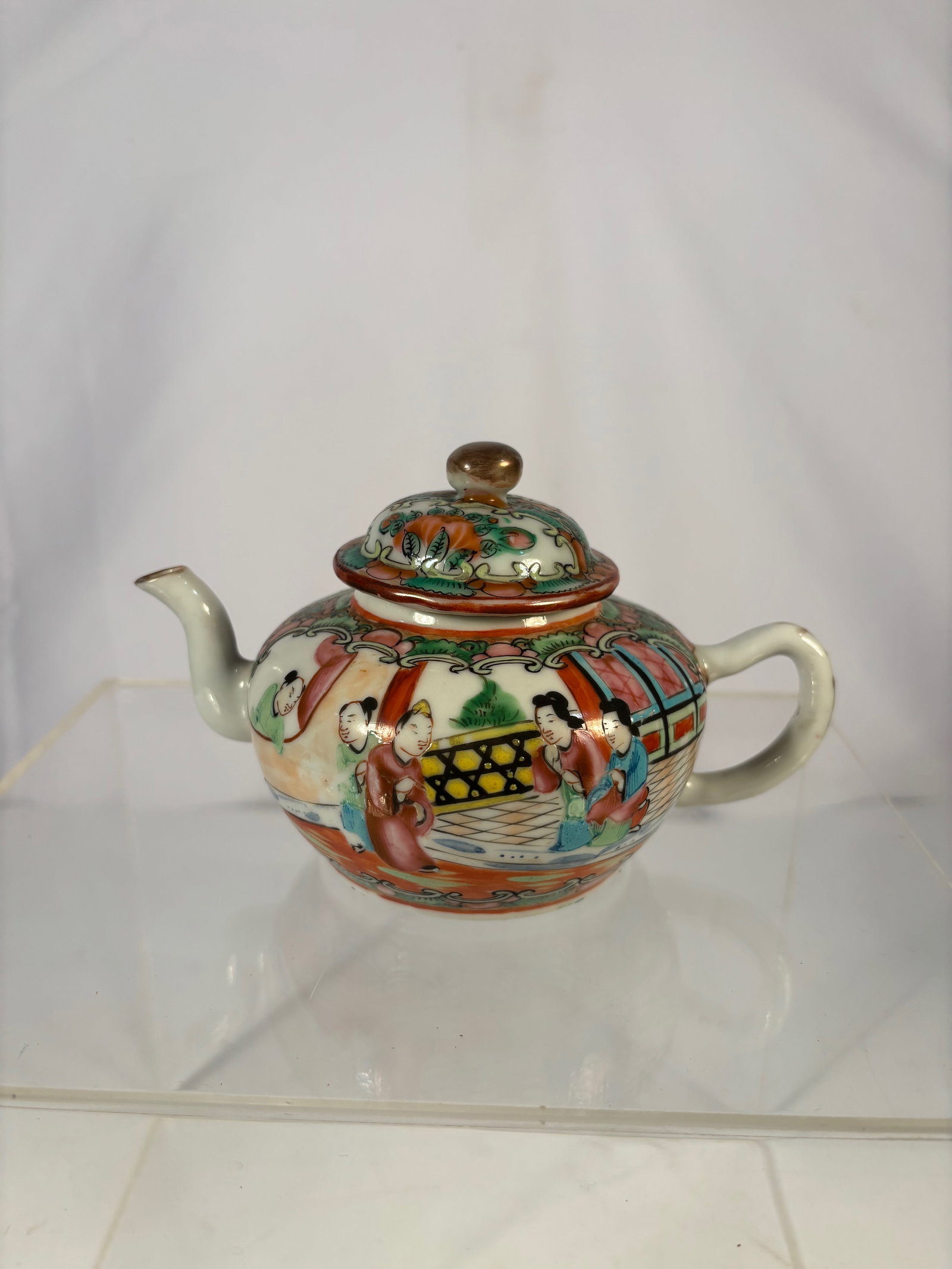 A Chinese famille rose porcelain teapot "CHINA?? Mark,: Qing dynasty(1644-1912); A fine Chinese export porcelain teapot of rounded form, decorated in Famille Rose enamels with courtly figures within garden scenes, surrounded by scrollwork and floral panels