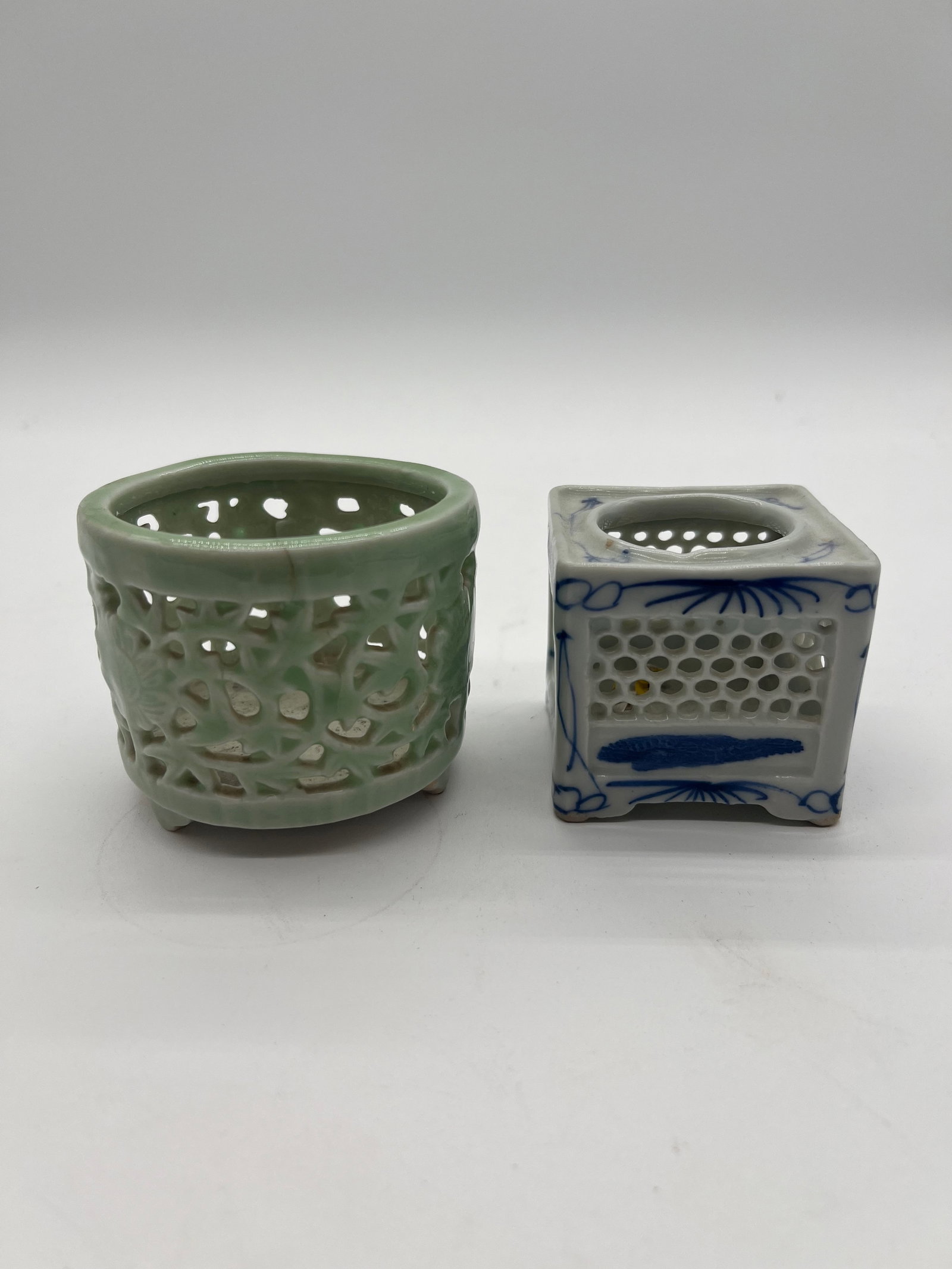Two Japanese reticulated porcelain incense burner: Late 19th century; The square-shaped item with blue and white decoration features geometric openwork. The Celadon-Glazed Piece has a small footed base. Dimensions?Depth: 2.5 inches / 6.35
