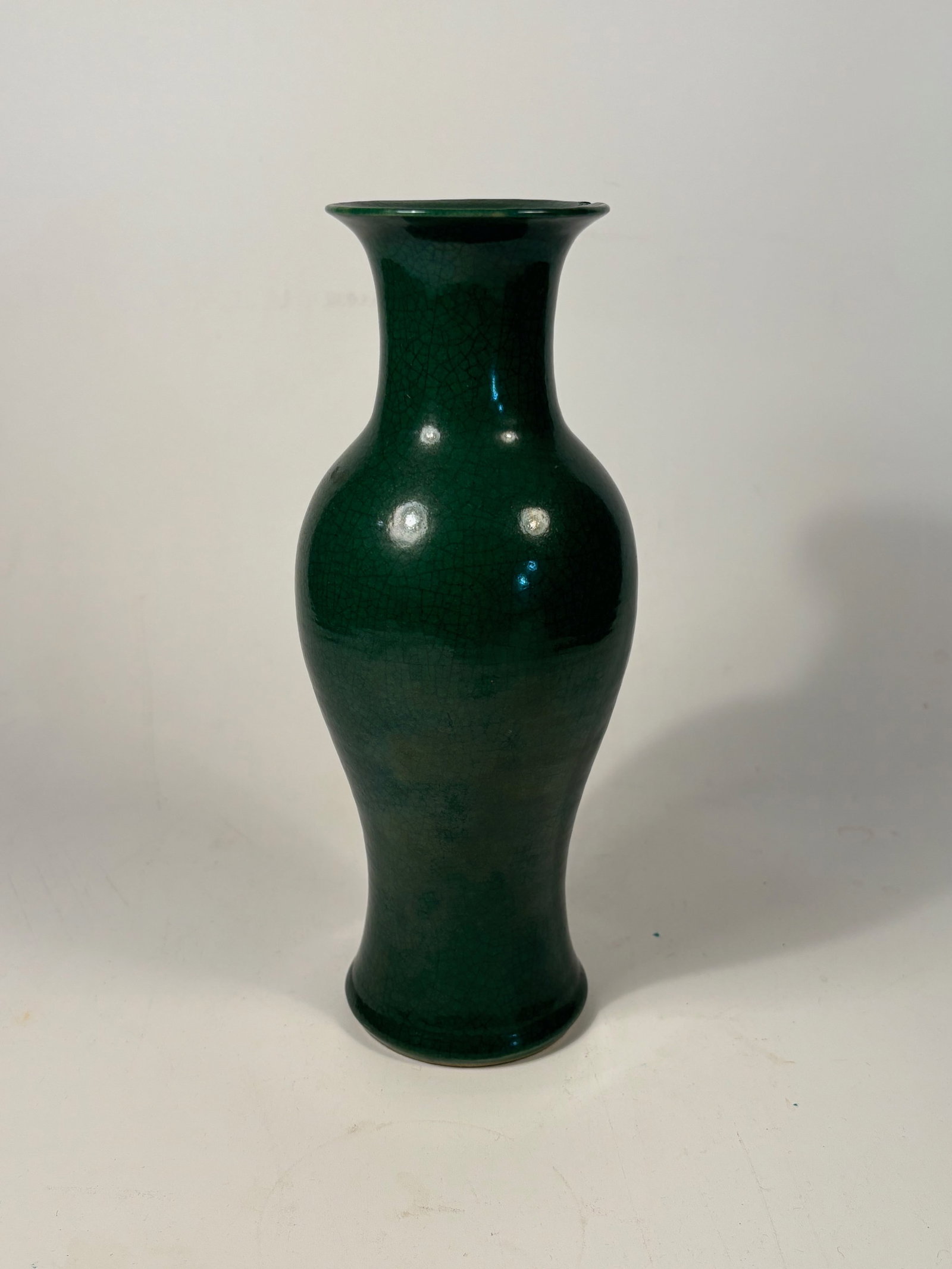 A Chinese monochrome green Ge-type crackle glaze porcelain vase: Qing dynasty(1644-1912); An elegant Chinese porcelain vase with a rich emerald green glaze in the Ge-type tradition, exhibiting a dense crackle network throughout the surface. The vase is of baluster 