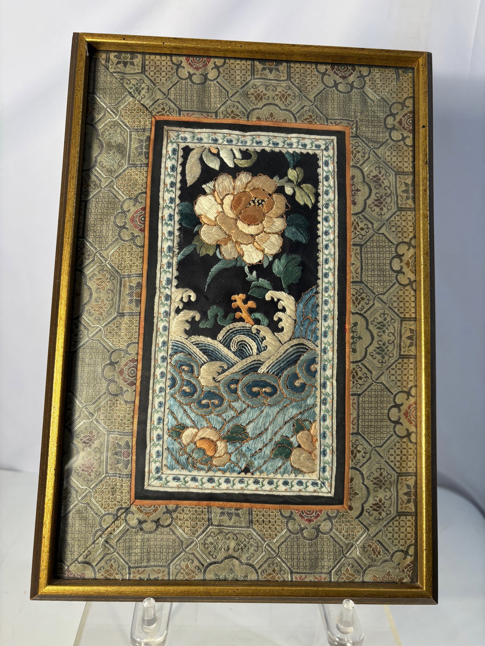 A Chinese Silk Embroidery Panel with Peony and Crashing Waves: Qing Dnasty(1644-1912), Antique Chinese silk embroidery panel, finely hand-embroidered on a dark silk ground depicting a blooming peony rising above stylized crashing waves. The peony symbolizes wealt