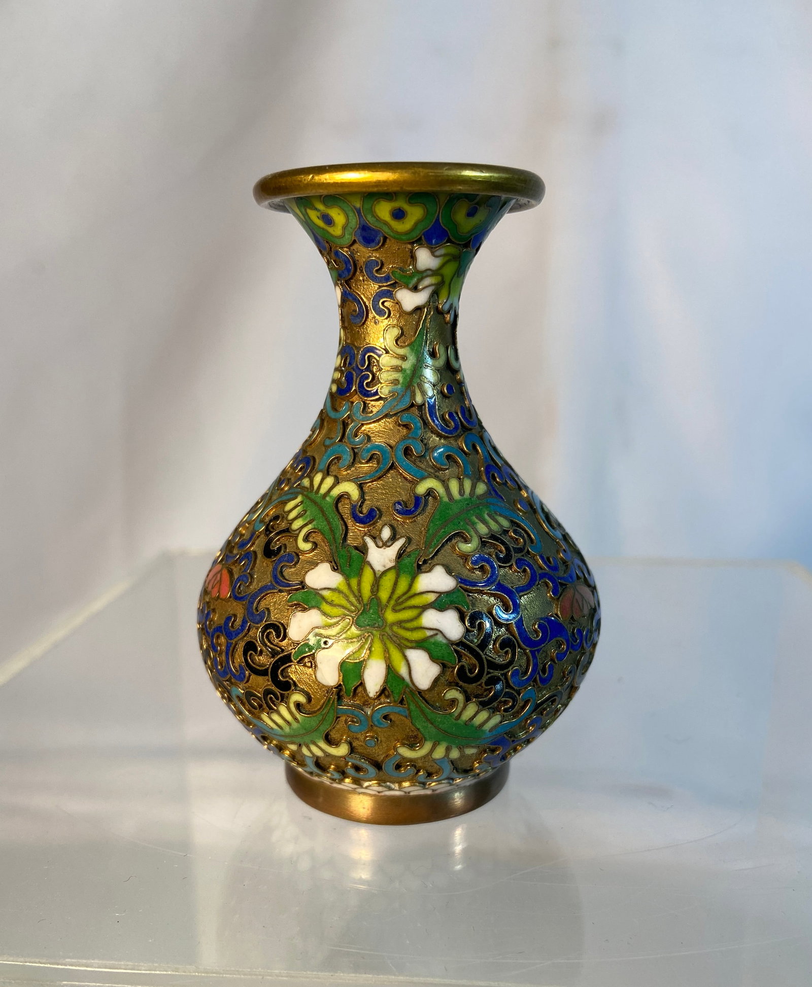 Chinese Cloisonné Enamel Miniature Bottle Vase: Chinese cloisonné enamel miniature bottle vase decorated with scrolling floral and foliate motifs in turquoise, cobalt blue, green, white, and pink enamels against a gilt bronze ground. The globular 