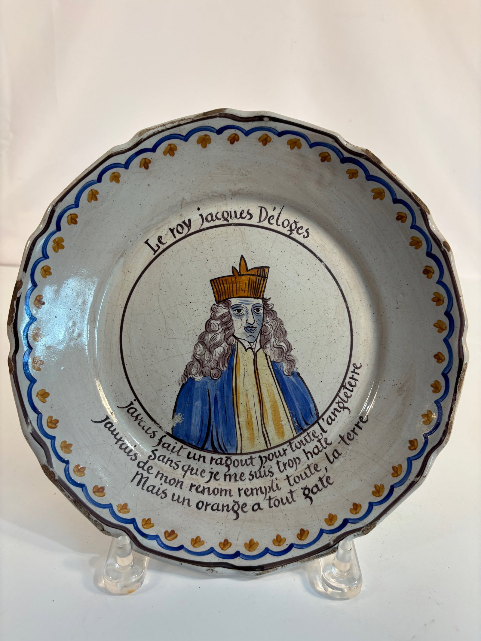 A French Nevers Faience Political Plate “Le Roy Jacques Délogé??, 18th Century: France, circa 1750–1780; A French faience plate hand-painted with a portrait of King James II of England, titled “Le Roy Jacques Délogé”, accompanied by a satirical French verse mocking hi