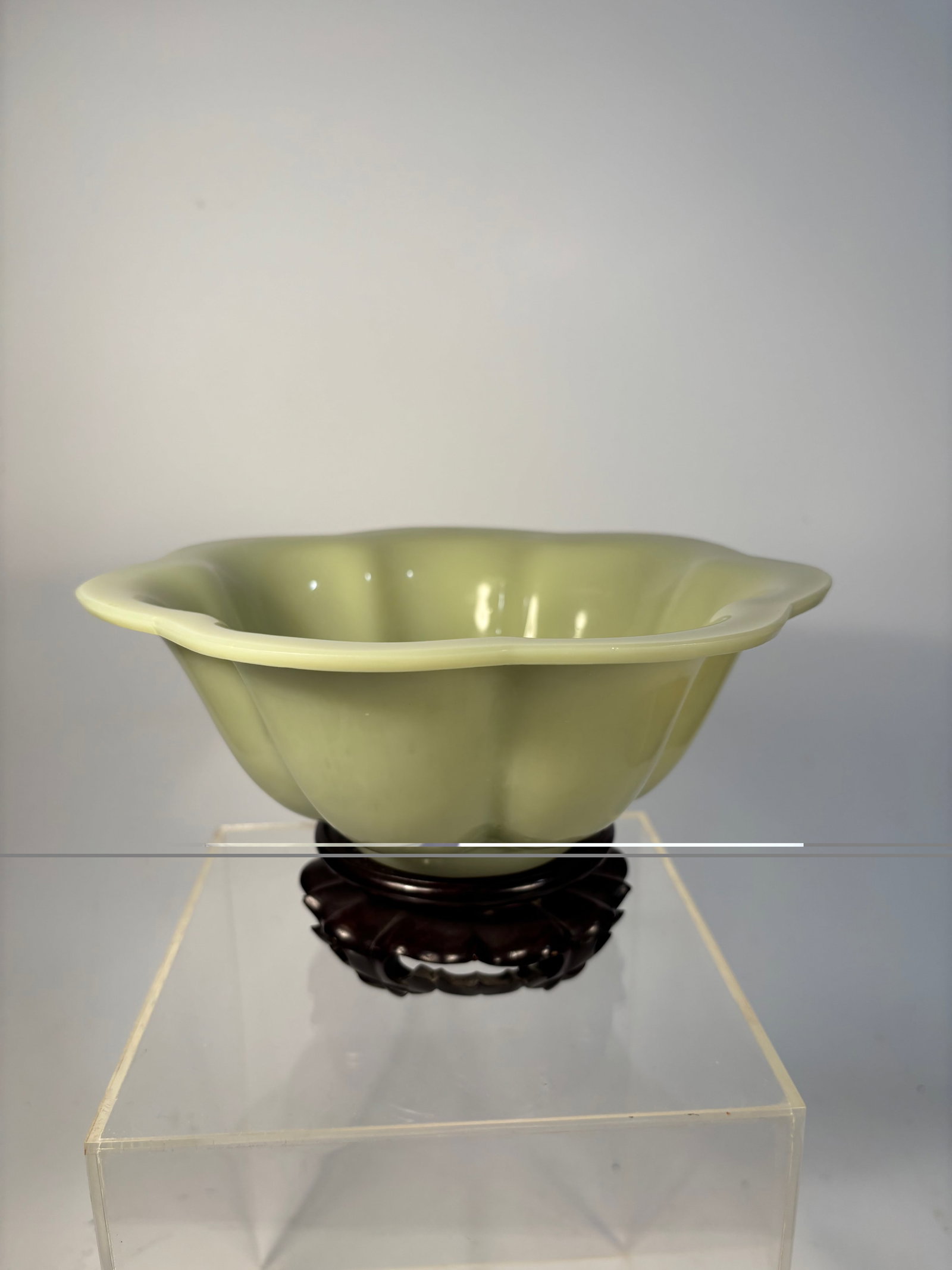 A Chinese Peking Glass Bowl – Celadon Yellow-Green jade like: Qing Dynasty(1644-1912); A luminous Chinese Peking glass bowl, molded in a lobed lotus blossom form with soft curves rising to a slightly flared rim. The glass is an elegant celadon yellow-green tone,