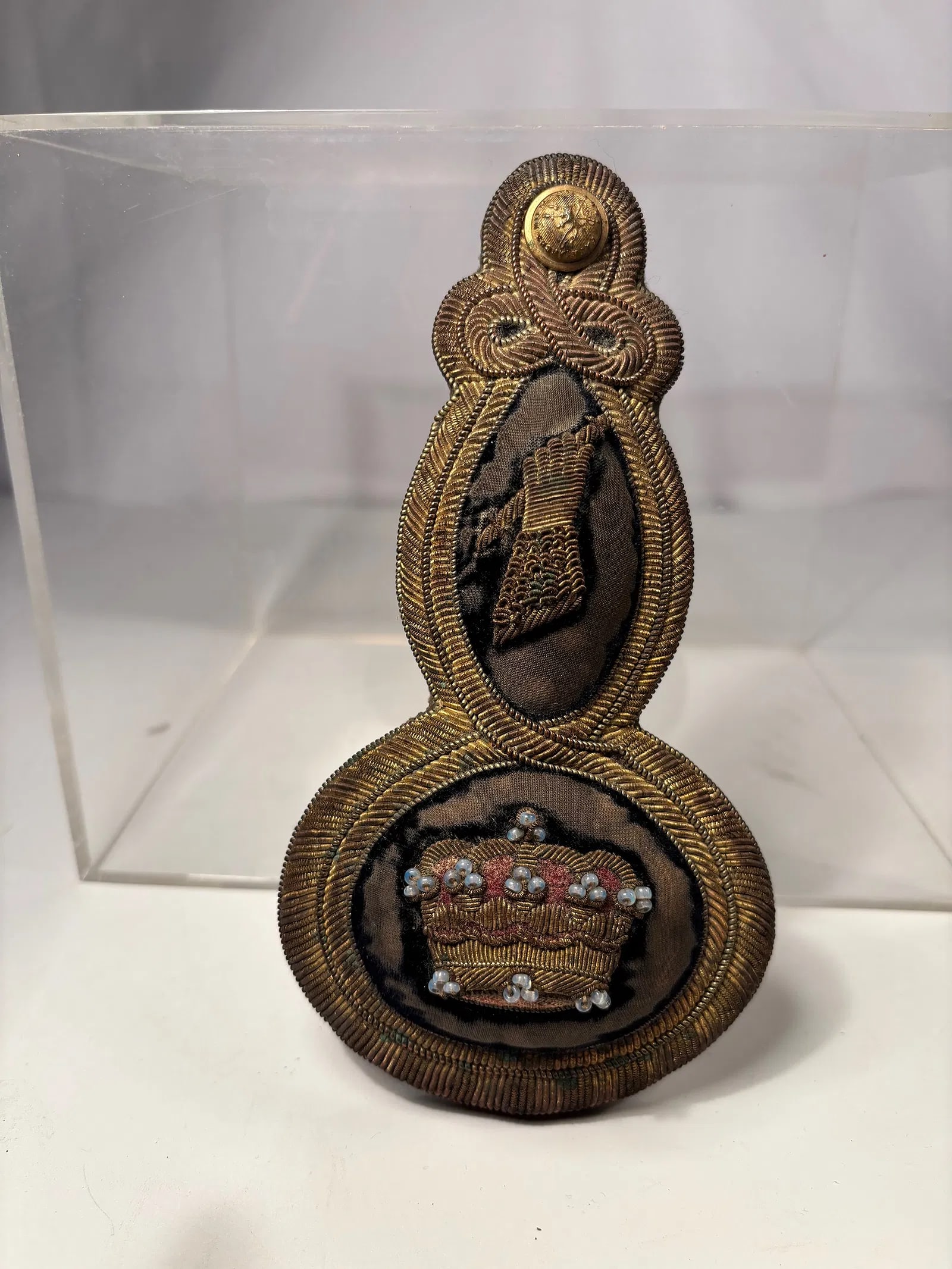 A Victorian British Officer’s Bullion-Embroidered Epaulette with Crown and Arm Device, c.: A fine Victorian British officer’s bullion-embroidered epaulette, circa 1850–1880, featuring an oval black velvet ground richly decorated with gilt wire embroidery. The upper medallion displays a 
