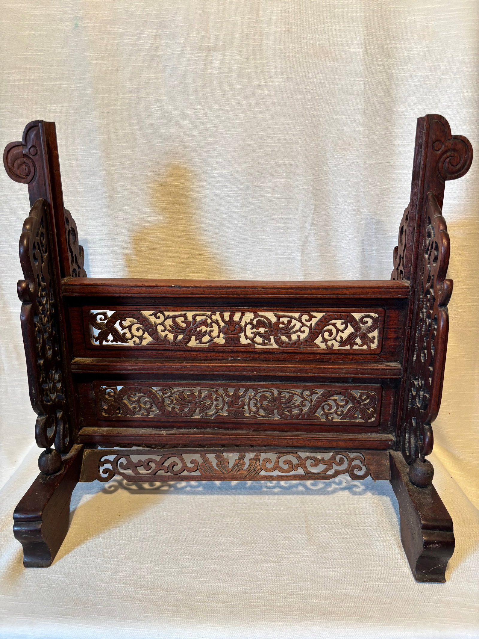 19th Chinese carved Huanghuali and mixwood table screen stand: A Chinese table screen stand crafted in a combination of hardwoods, including huanghuali wood and mixed woods. The stand features finely carved openwork panels with scrolling floral motifs and traditi