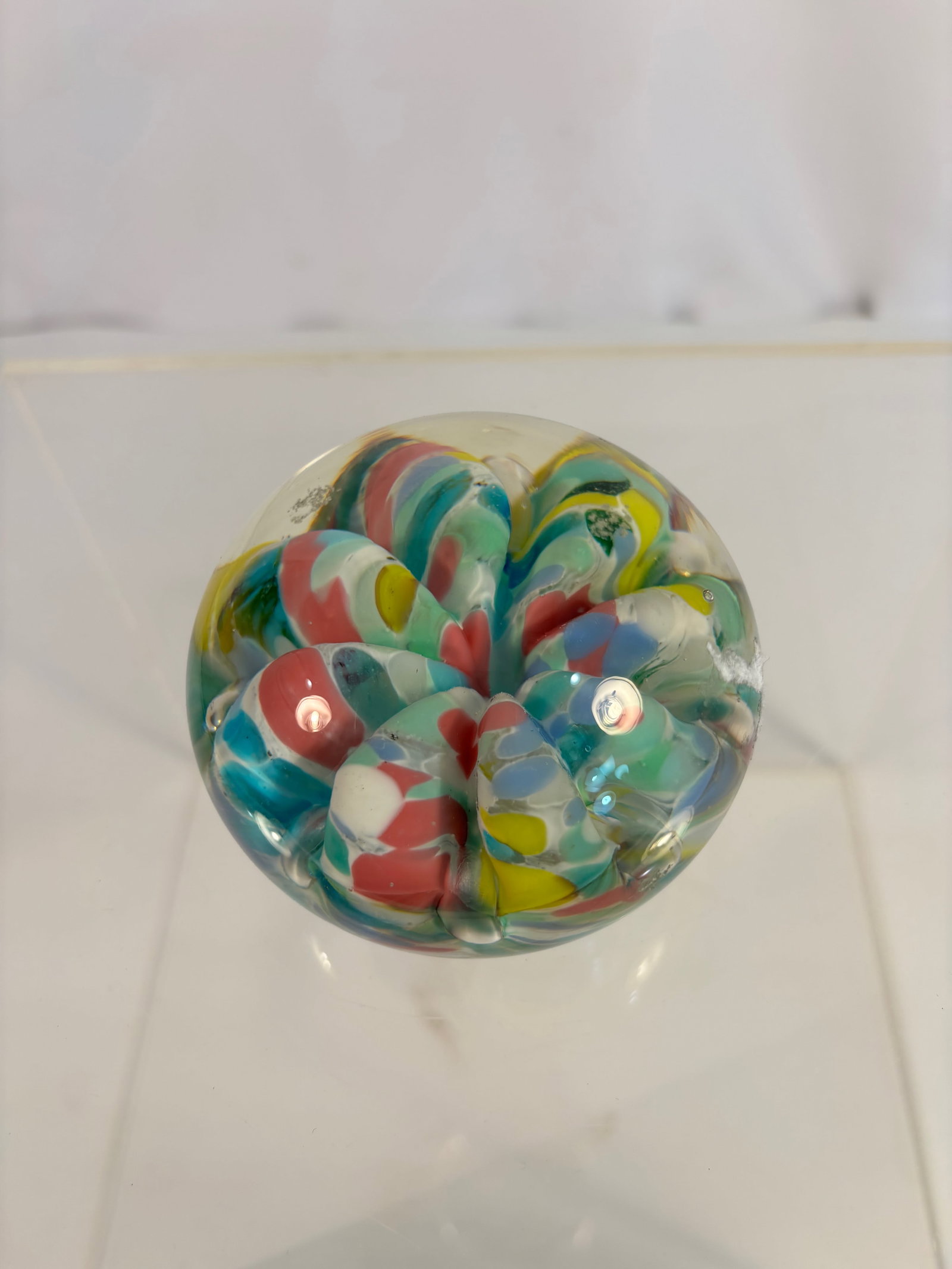 1976 St. Clair Hand-Made Art Glass Paperweight, Multicolor Swirl Design: Vintage art glass paperweight by the St. Clair Glass Studio, dated 1976 and marked on base “HAND MADE BY ST. CLAIR 1976.” The clear glass sphere encases layered multicolor ribbon and teardrop 