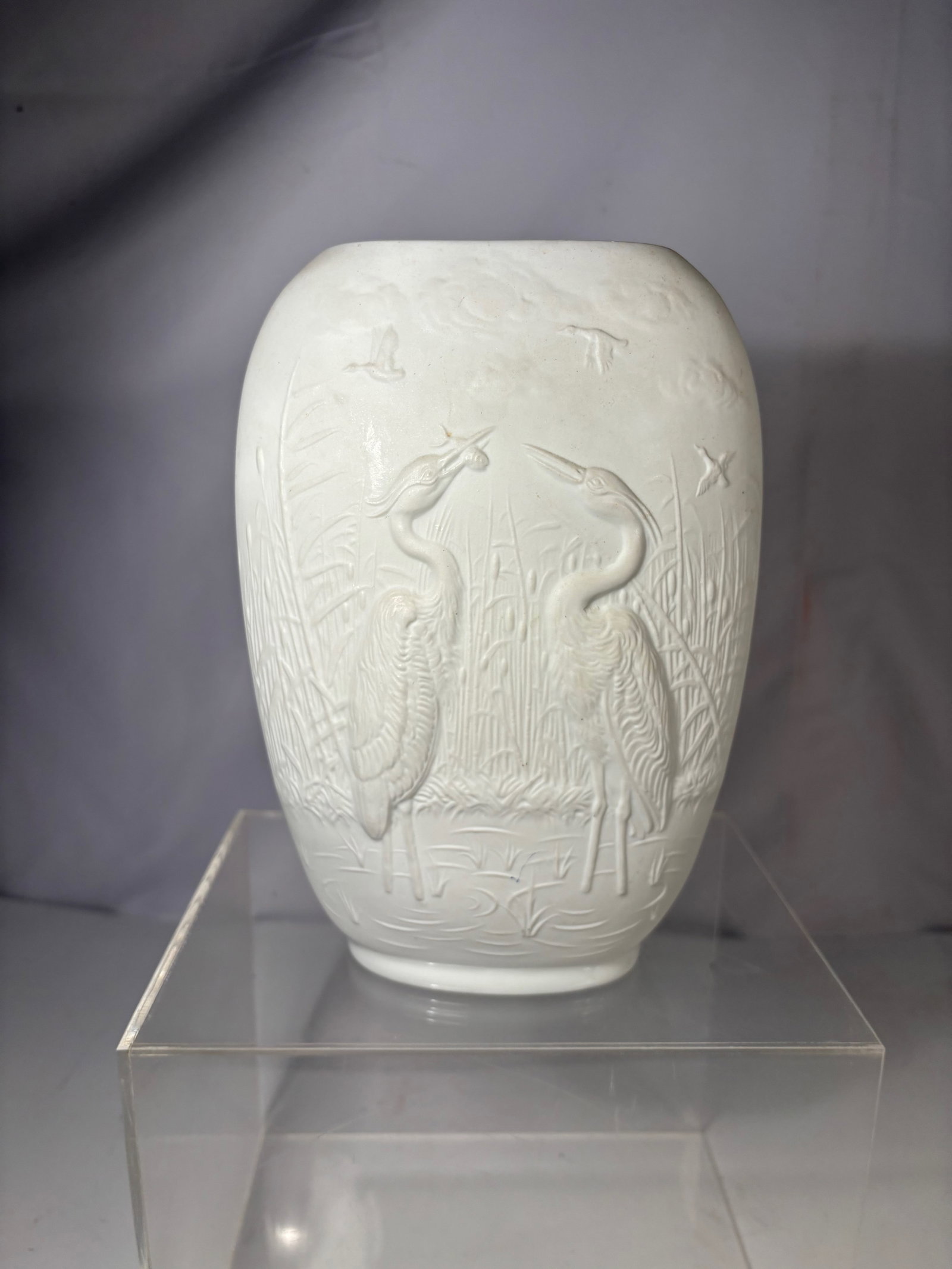 A Royal Porzellan Bavaria KPM Germany Porcelain Relief Vase: German porcelain vase by Royal Porzellan Bavaria (KPM), featuring molded relief decoration of cranes in a marsh landscape. Marked on underside “Royal Porzellan Bavaria KPM Germany Handarbeit.”