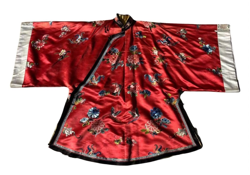 A Large Chinese Rotyal Red Silk Embroidered Robe: Qing Dynasty(1644-1912); This richly embroidered Chinese robe features a vibrant red silk ground adorned with intricate floral and butterfly motifs rendered in satin and couching stitch embroidery, us