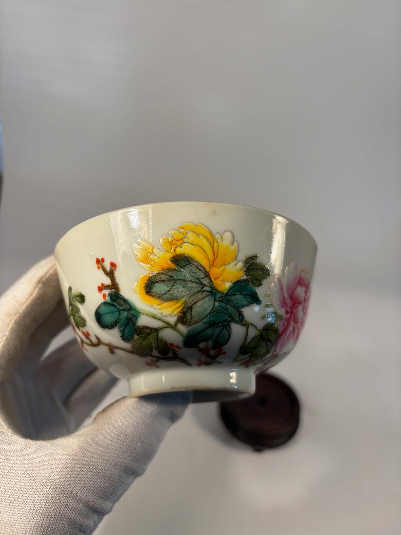 A Chinese Famille Rose Porcelain Bowl with Red Seal Mark: 19th century; A finely enamelled Chinese porcelain tea bowl, decorated in the famille rose palette with lush blooming peonies in pink, yellow, and green foliage on a white ground. The bowl rests on a 