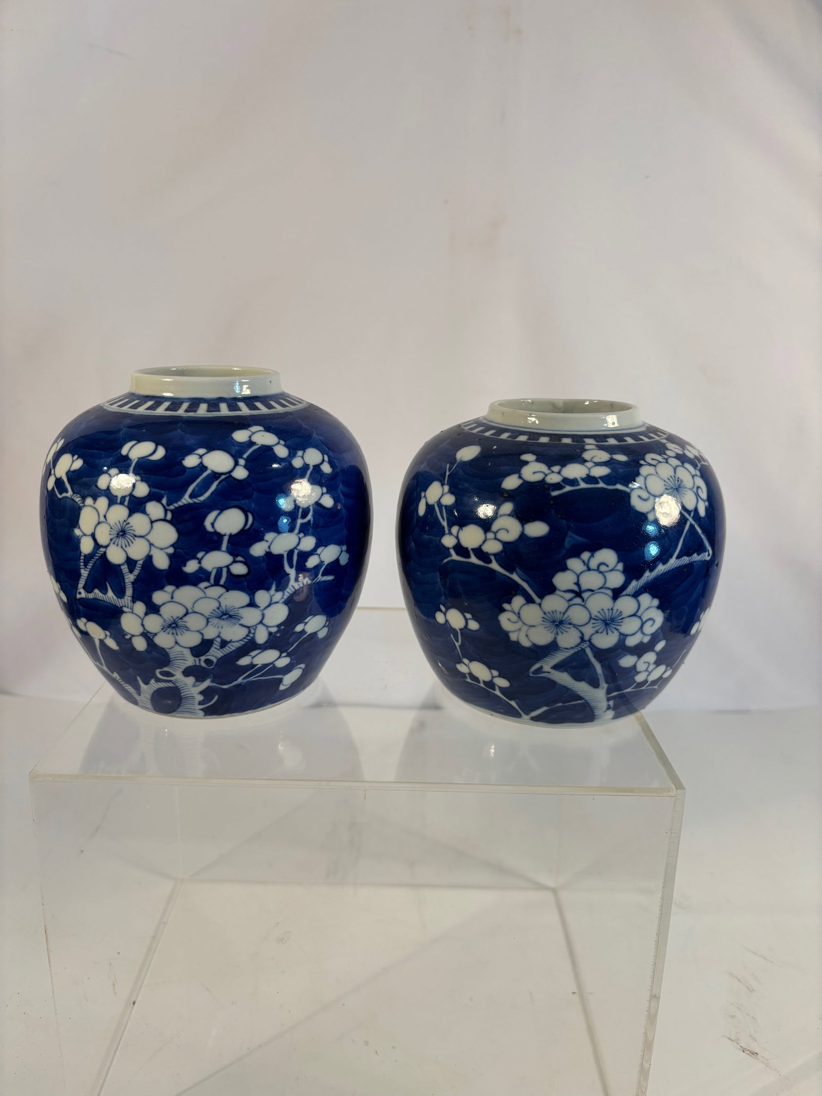 Pair of Chinese Blue and White ‘Prunus on Ice-Crack Ground’ Porcelain Jars: Qing dyansty(1644-1912) ; A blue and white porcelain jar decorated with prunus blossoms against the classic “ice-crack” ground. The rounded body features white flowering plum branches in reser