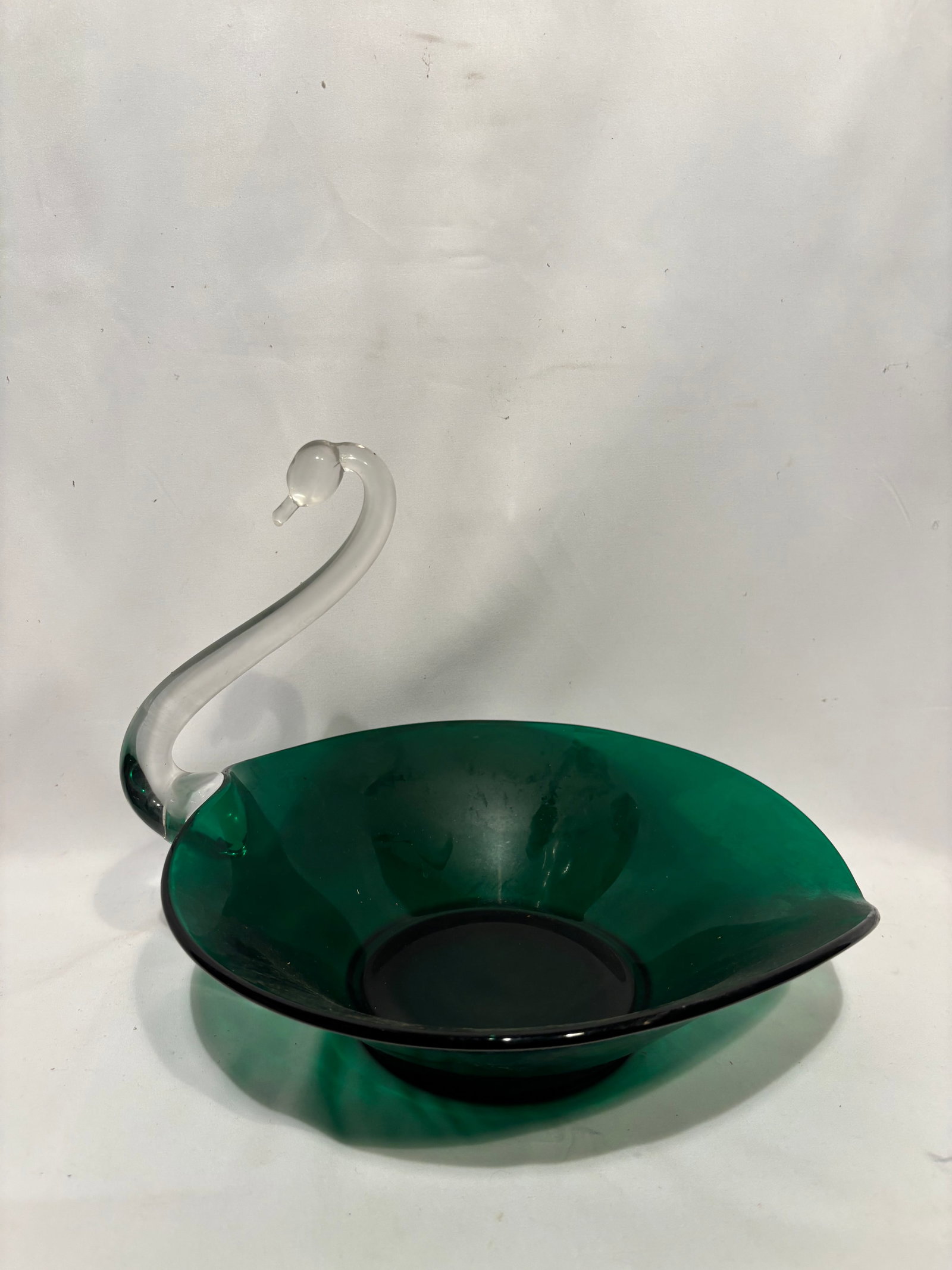 Murano Style Art Glass Swan Centerpiece Bowl, 20th Century: Elegant hand-blown art glass centerpiece formed as a stylized swan, featuring a clear curved neck and head rising from a deep emerald-green body. The elongated oval bowl is gracefully shaped with a pu