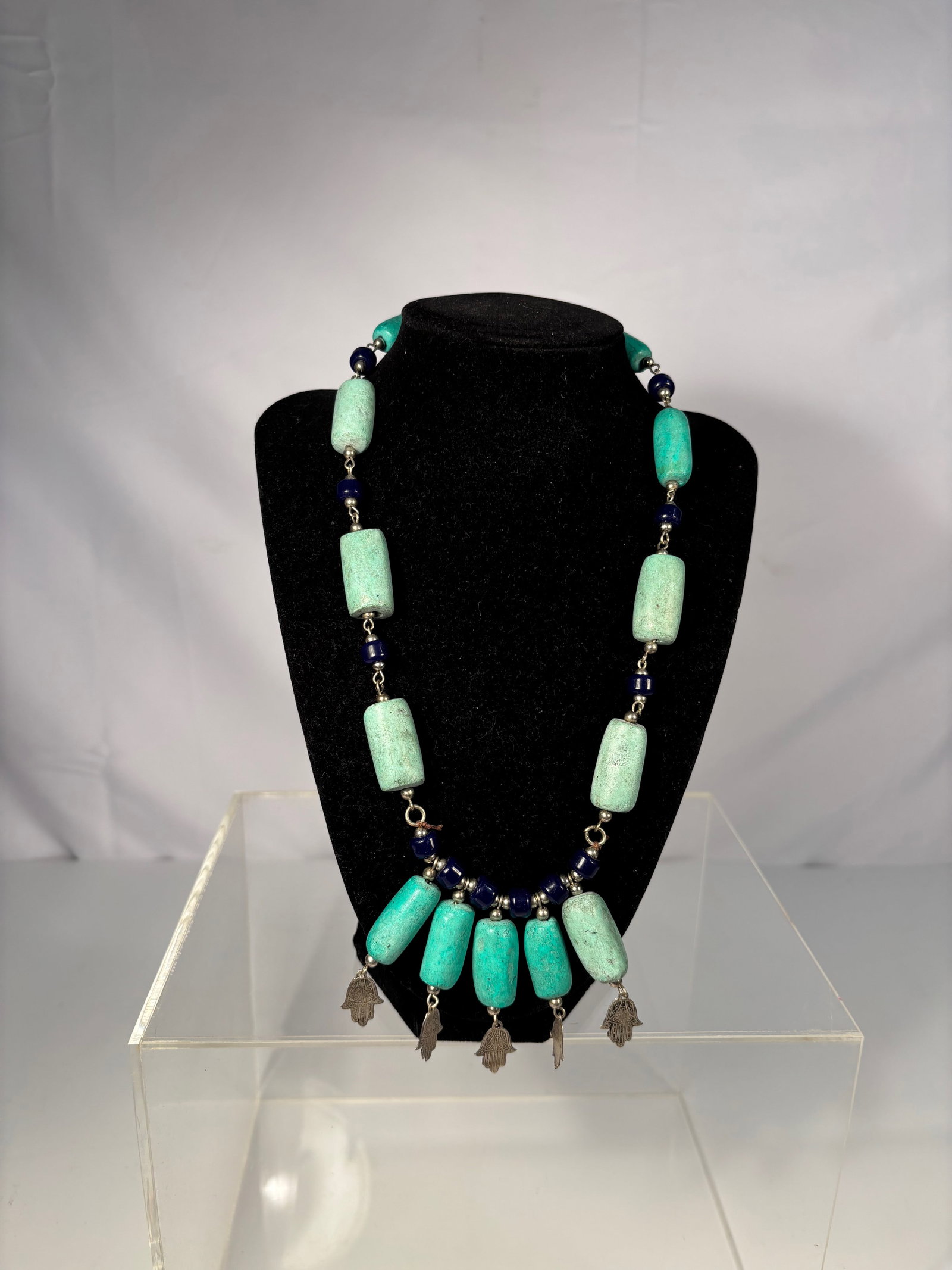 Antique Ethnic Necklace with Very Old Natural Turquoise Beads and Dark Blue Accents: An antique tribal-style necklace featuring large, hand-cut very old natural turquoise barrel beads, their surfaces displaying age-appropriate wear and natural patina. The turquoise exhibits soft blue 