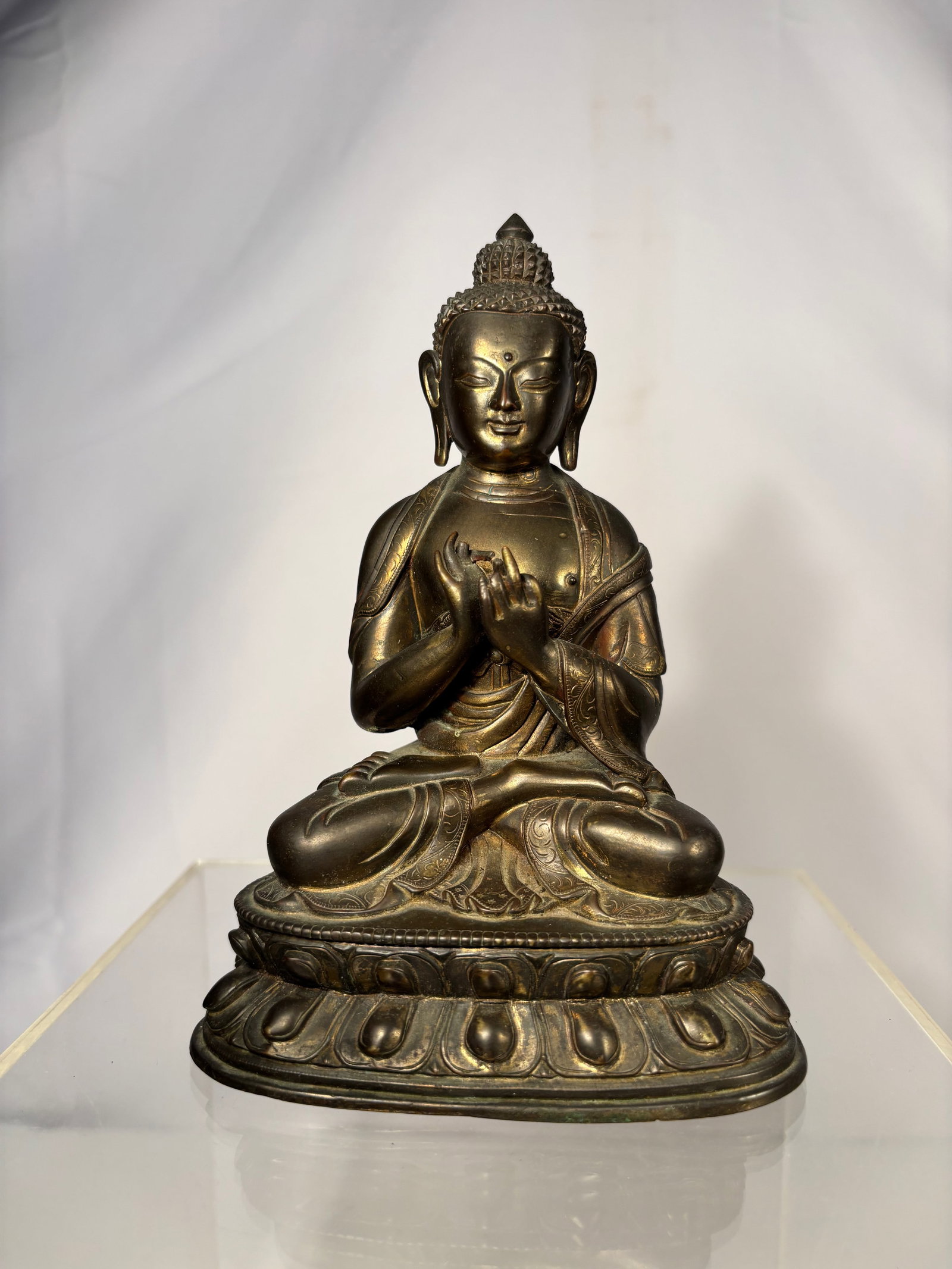 A Chinese Gilt Bronze Seated Buddha Figure: Qing Dynasty (1644-1912); A Chinese gilt bronze seated Buddha figure, depicted in a meditative posture with hands held before the chest. The figure is finely cast with serene facial expression, elonga