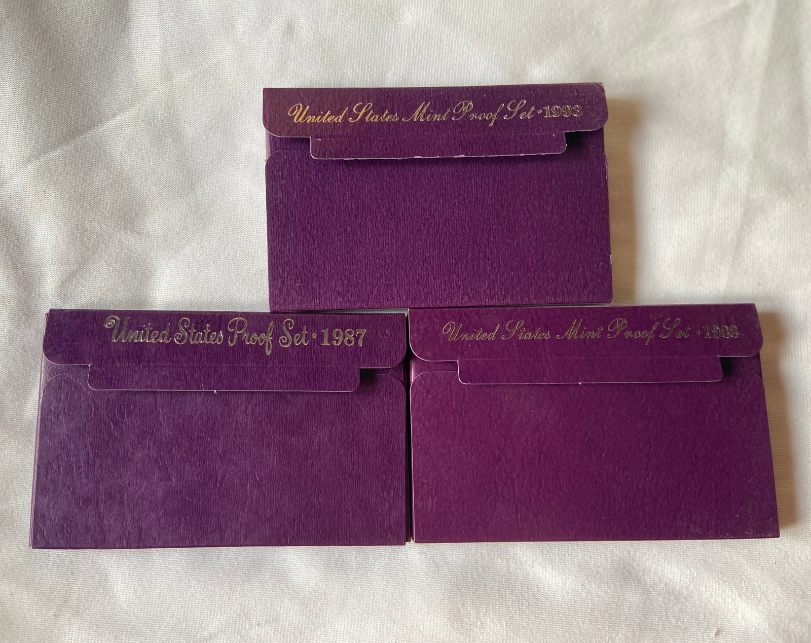 Three United States Mint Proof Sets, 1987, 1988 & 1993: Group of three official United States Mint proof coin sets including 1987, 1988, and 1993 examples. Each set contains mirrored proof-strike United States coinage housed in original government plastic 