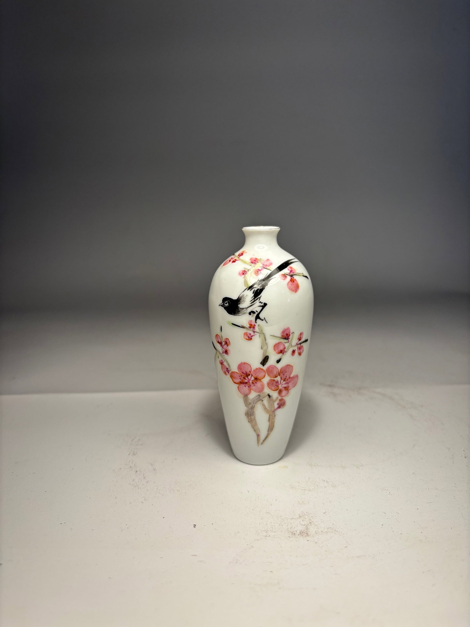 A Chinese Famille Rose â€˜Magpie and Plum Blossomâ€™ Miniature Vase, JINDEZHENG Mark: Early 20th centry; A Chinese famille rose porcelain miniature vase, finely enameled with a magpie perched on a blossoming plum branch, with poetic inscription and seal mark.Dimensions? Height: 3.75 in