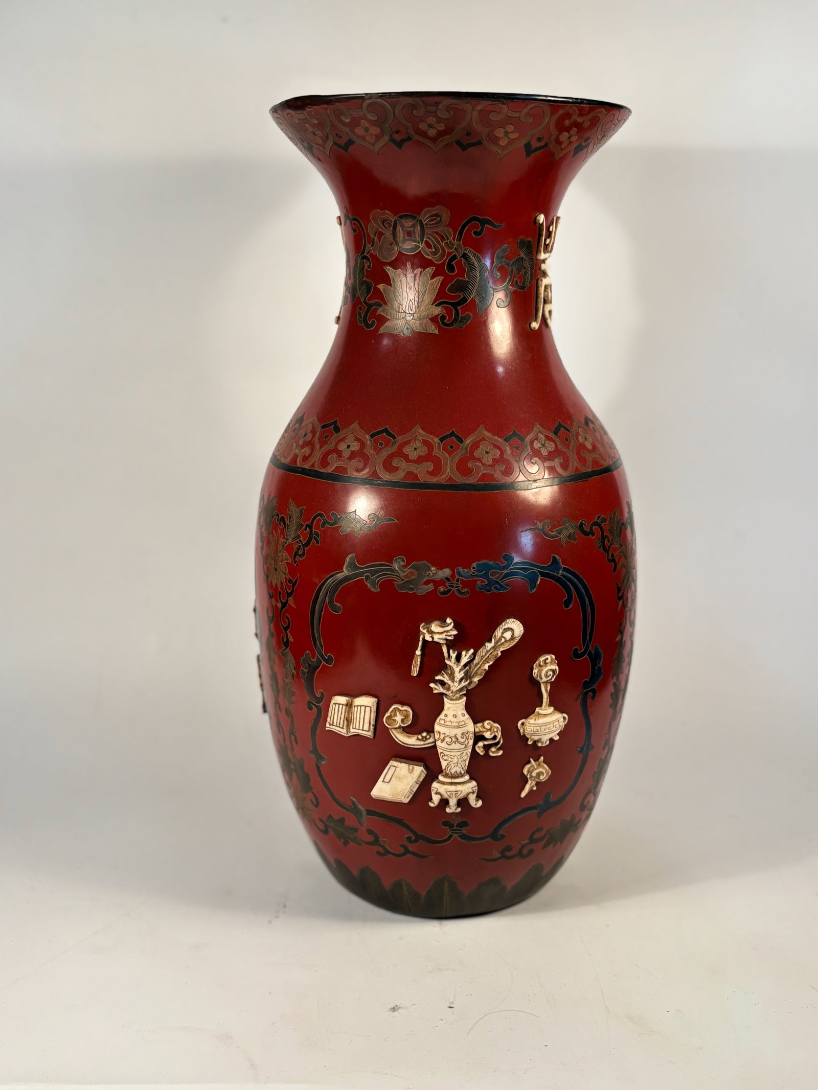 A Chinese Red Lacquer Vase with Gilt Decoration: Qing dynasty(1644-1912) ; A striking Chinese cinnabar red lacquerware vase, featuring intricate polychrome and gilt decoration on a flared baluster form. The body is adorned with raised and painted de
