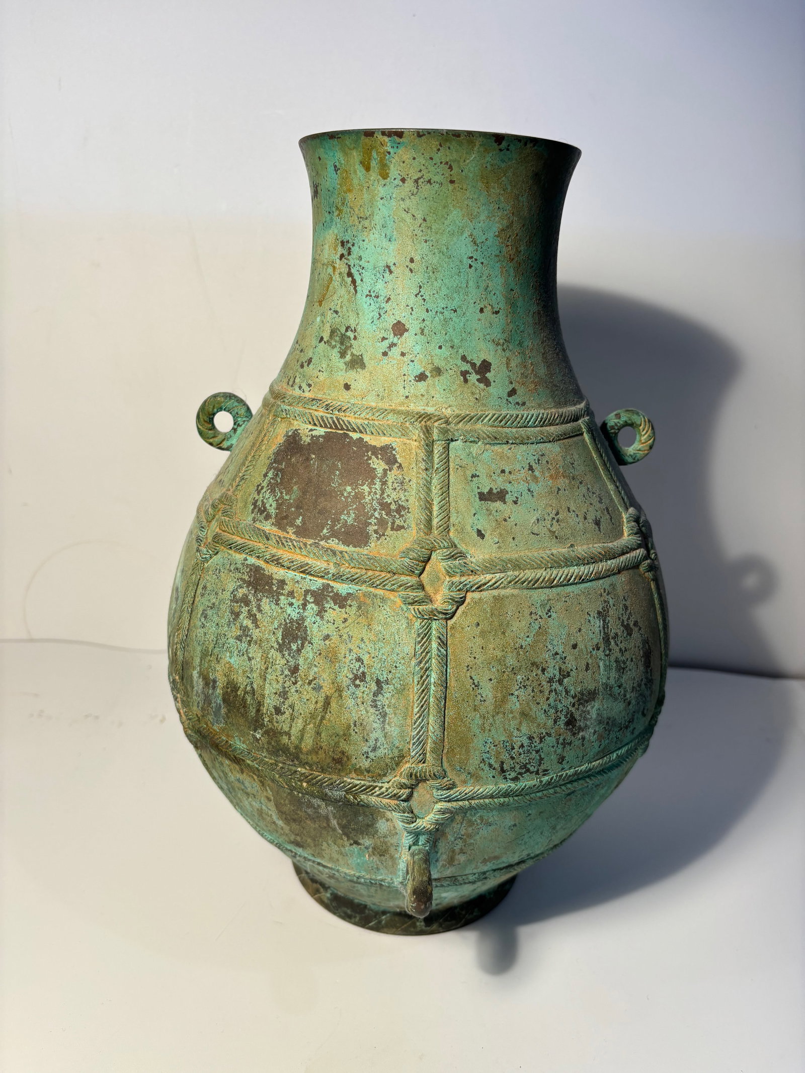 An archaic bronze vase, hu, China, probably Han Dynasty: Probably Han Dynastyof globular form, flanked by two small loop handles, the body encircled by two raised fillets, the ground with malachite encrustations.Provenance: From an prominent Midwest family 