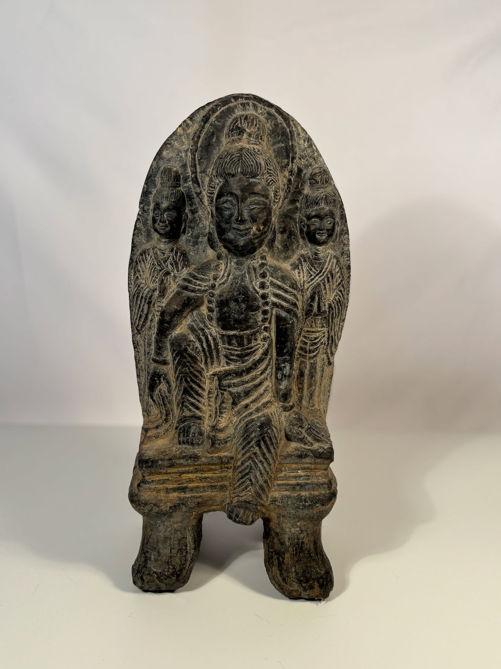 A Chinese Carved Stone Stele Depicting Bodhisattva, Inscribed “Jingping Yuan Nian: A Chinese carved stone stele depicting a central Bodhisattva flanked by two attendants, all rendered in high relief with fine linear detail. The Bodhisattva wears a beaded necklace and robes with vert