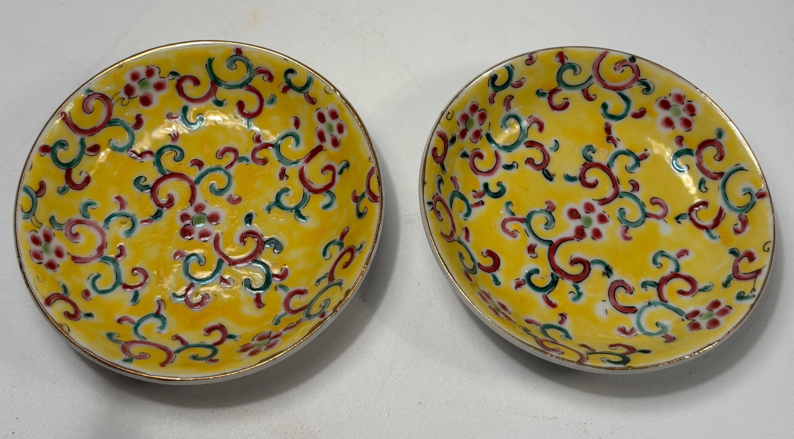 A pair of Chinese Famille Jaune-Style Porcelain dishes with mark: Republic period (1912-1949) ; Each finely enameled on a bright yellow ground with colorful scrolling lotus and foliage motifs in the Qing dynasty style. Dimensions? DIAMETER: 3.75 inches. Height: 1 in
