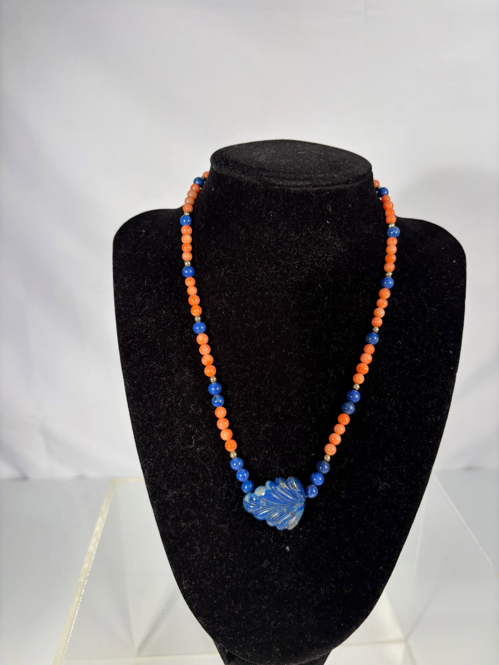 Coral and Lapis Lazuli Necklace with Carved Lapis Pendant and 14K Gold Beads: A vintage necklace composed of alternating salmon-orange coral beads and deep blue lapis lazuli beads, accented with 14k gold spacers and centered by a hand-carved lapis lazuli leaf-shaped pendant. A 