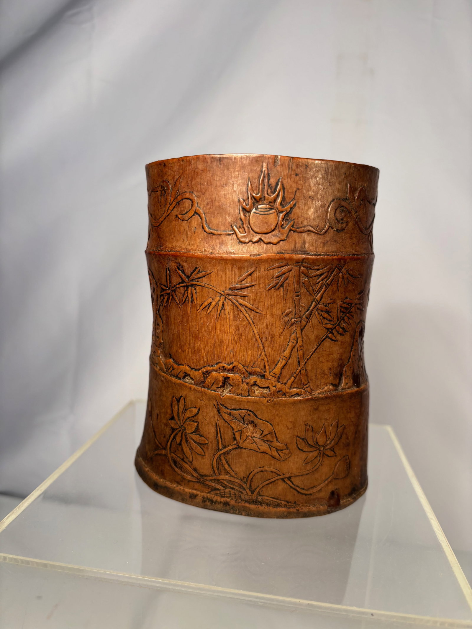 A Chinese Carved Bamboo Double Brush Pot, “Zhishan Zhuren?? Mark , 17-18 th century: A Chinese carved bamboo double brush pot, is formed as two vertically joined cylindrical vessels, carved from mature bamboo with a warm, naturally aged patina. The exterior is finely decorated in low 