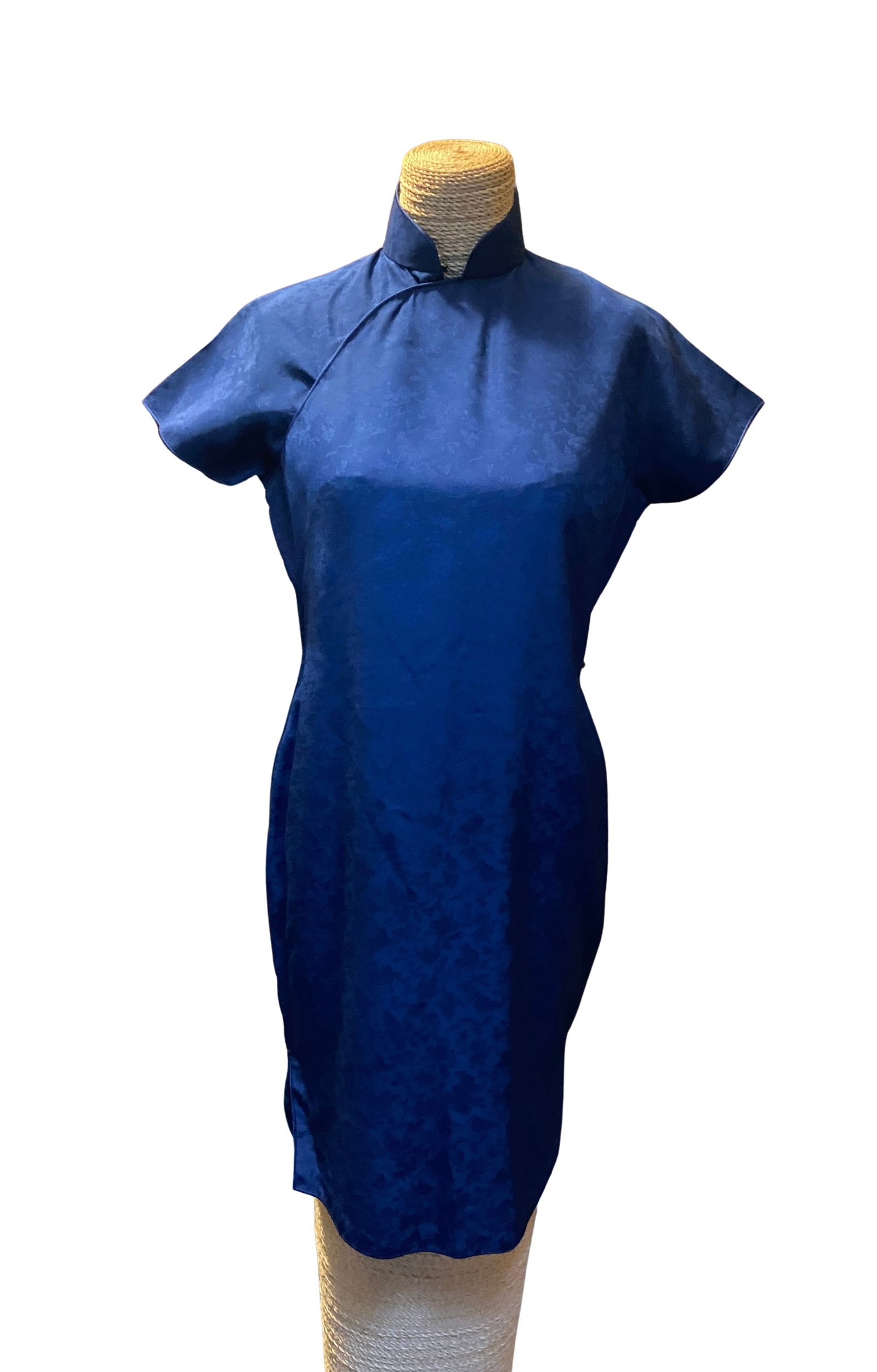 Vintage Chinese Navy Blue Silk Brocade Qipao (Cheongsam) Dress: An elegant vintage Chinese qipao (cheongsam) in a rich navy blue silk brocade featuring an all-over woven floral pattern. The dress has a timeless Mandarin collar, cap sleeves, a tailored sheath silho