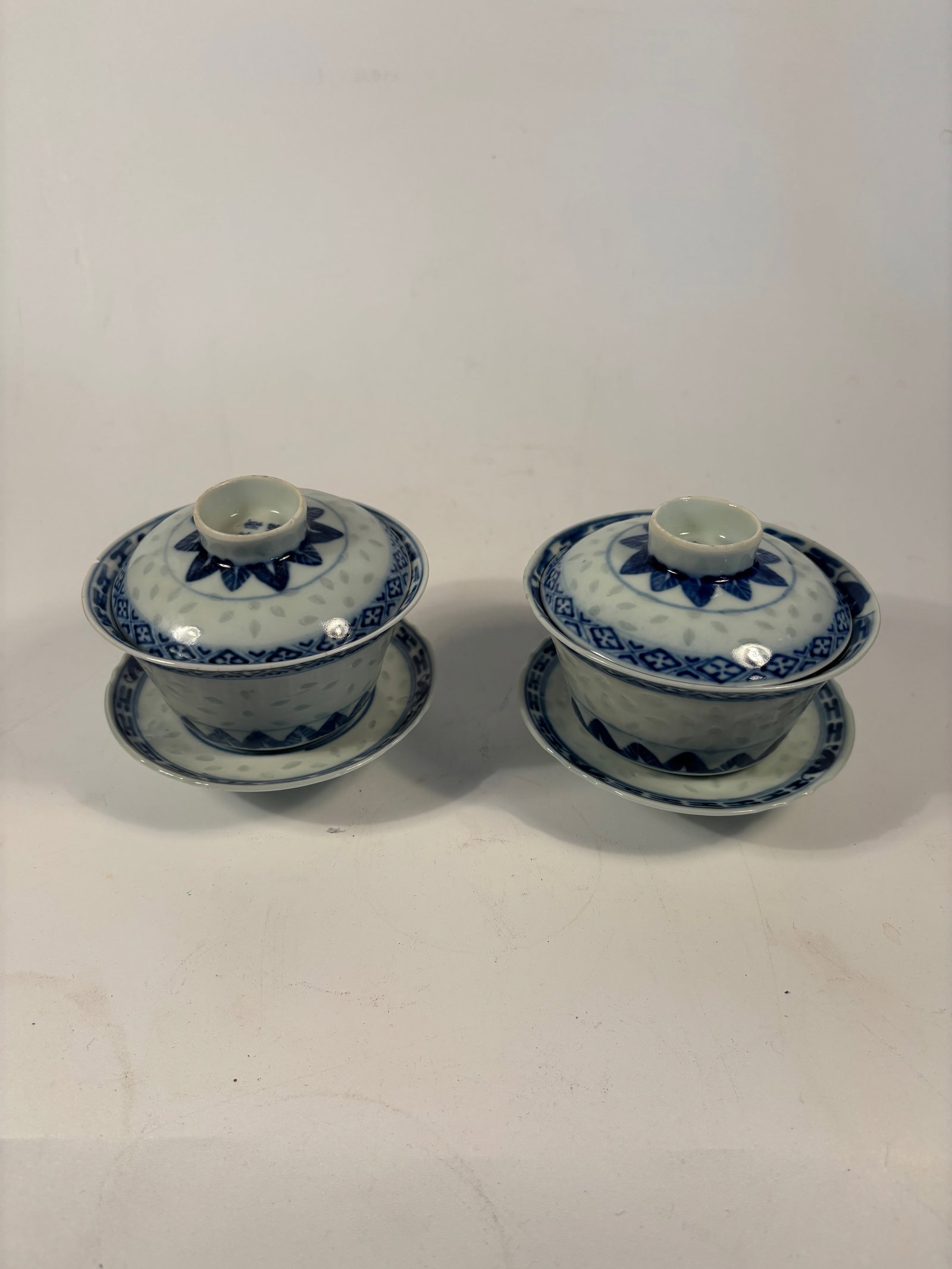 Pair of Chinese blue and white porcelain covered tea bowls with matching saucers: Qing dynasty(1644-1912); A fine pair of Chinese blue and white porcelain tea bowls (gaiwan) with domed lids and matching saucers. Each piece is delicately decorated with underglaze cobalt blue floral 